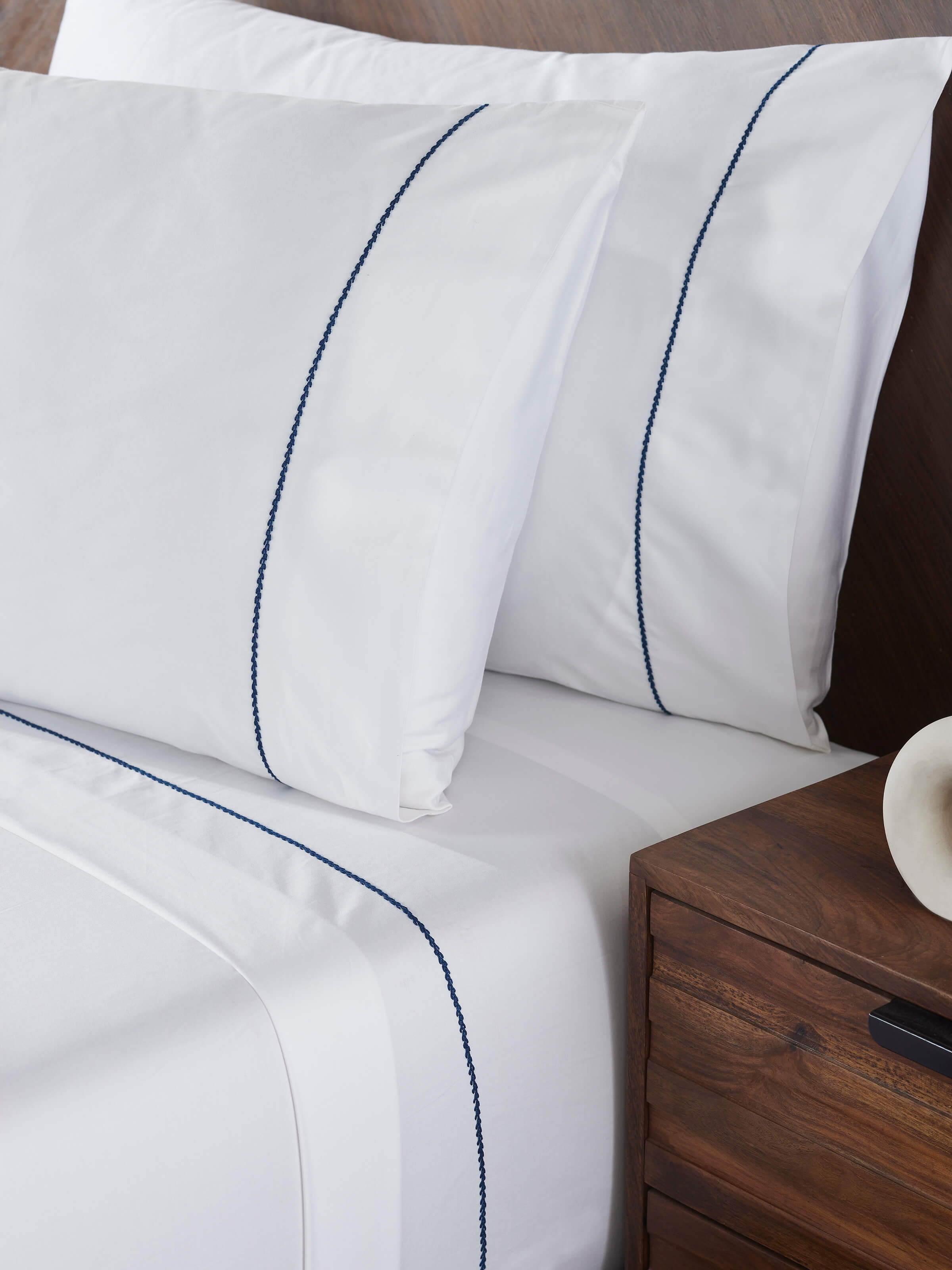 Side view of Shivranjini blue stripe cotton hand embroidered bedsheet king set (3 pcs), highlighting the texture and stitching.