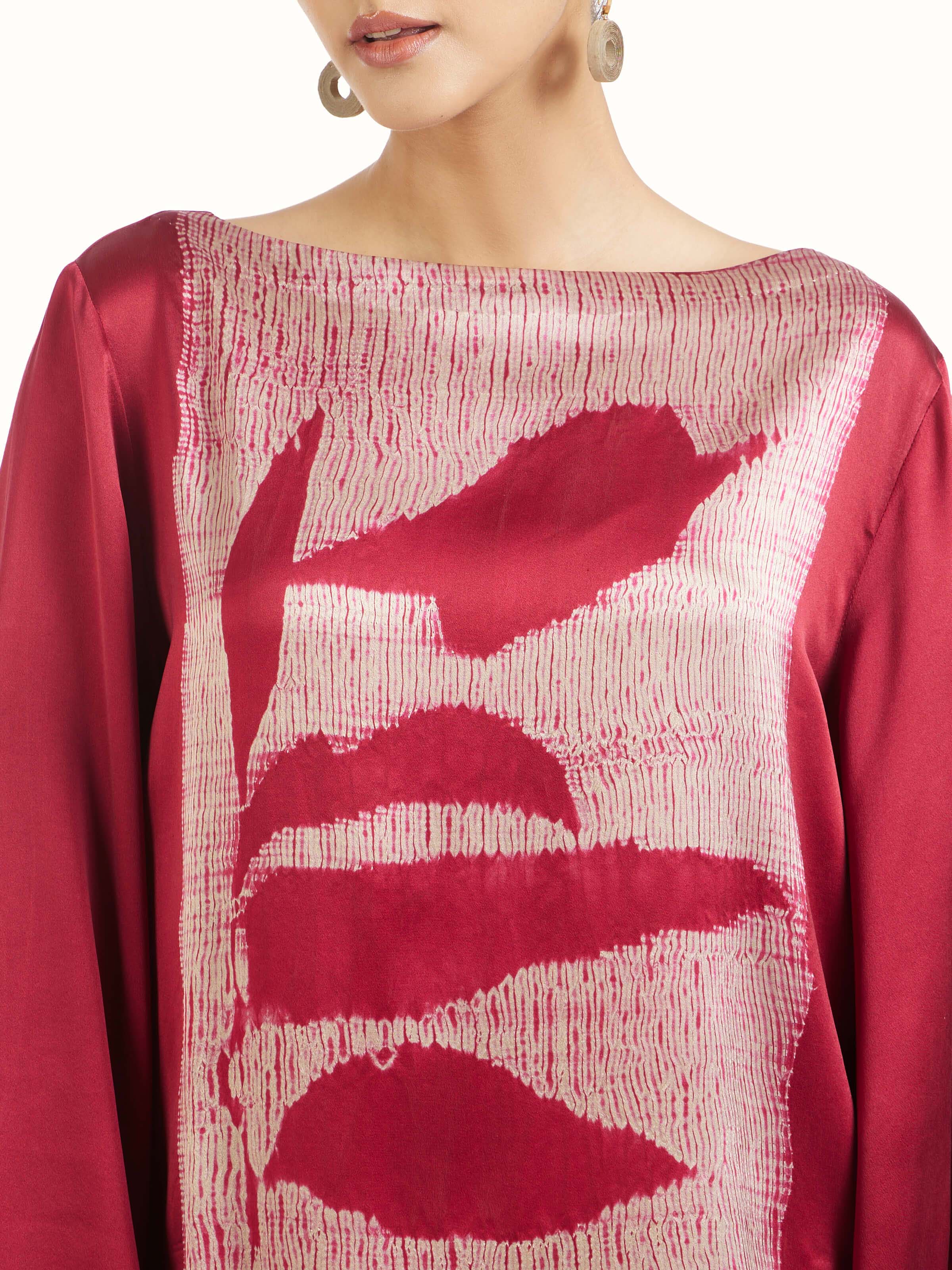 Detail view of red satin Shibori top showcasing craftsmanship and fabric texture