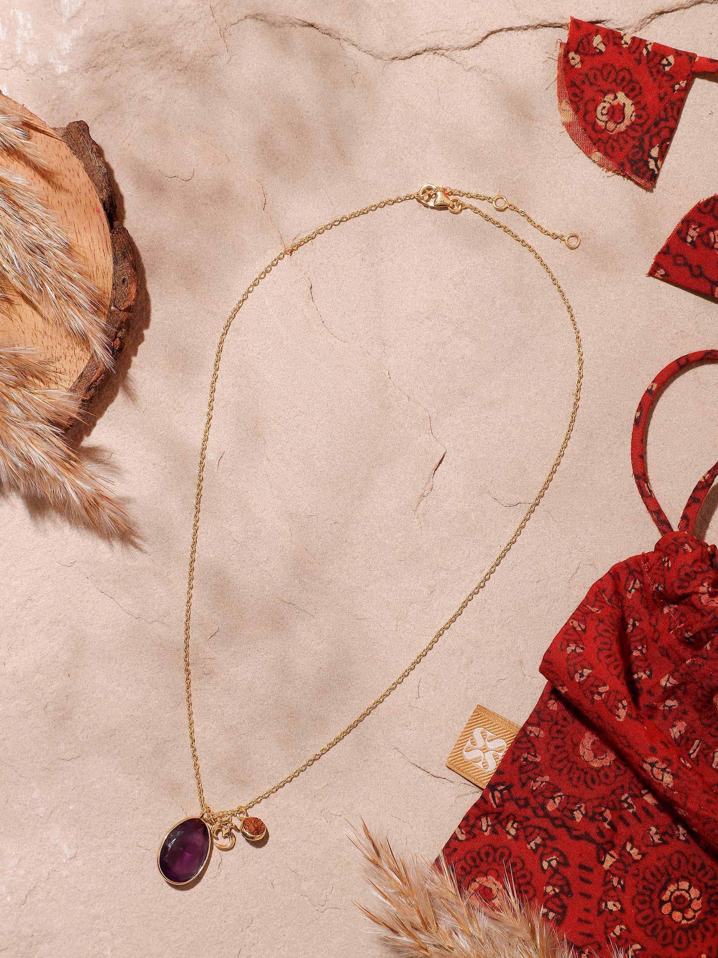 Lifestyle view of Rudraksha and Amethyst necklace featuring Om charm in 18K gold-plated silver setting