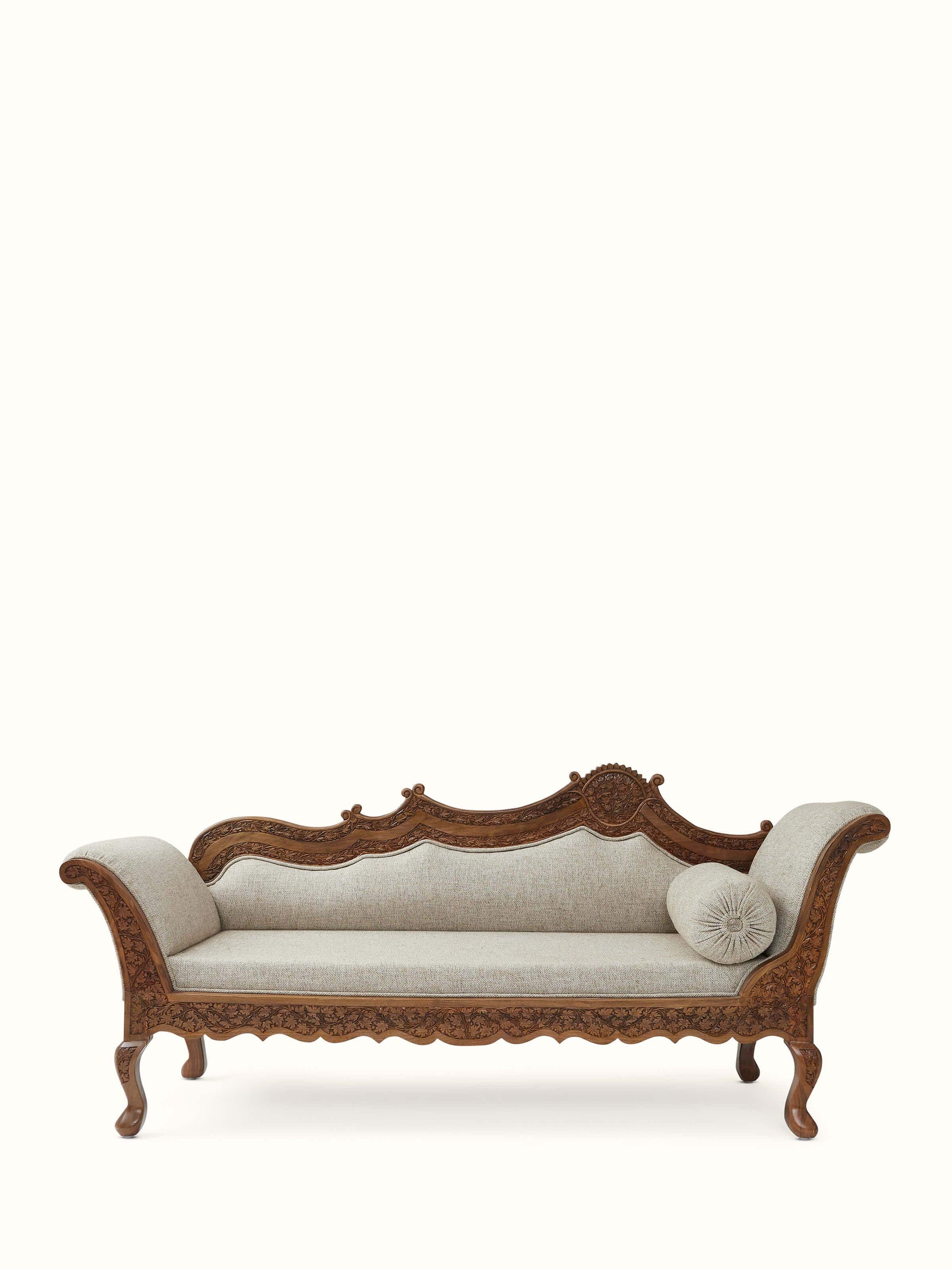 Front view of the handloom fabric upholstered carved walnut wood daybed, showcasing the detailed carving and fabric upholstery