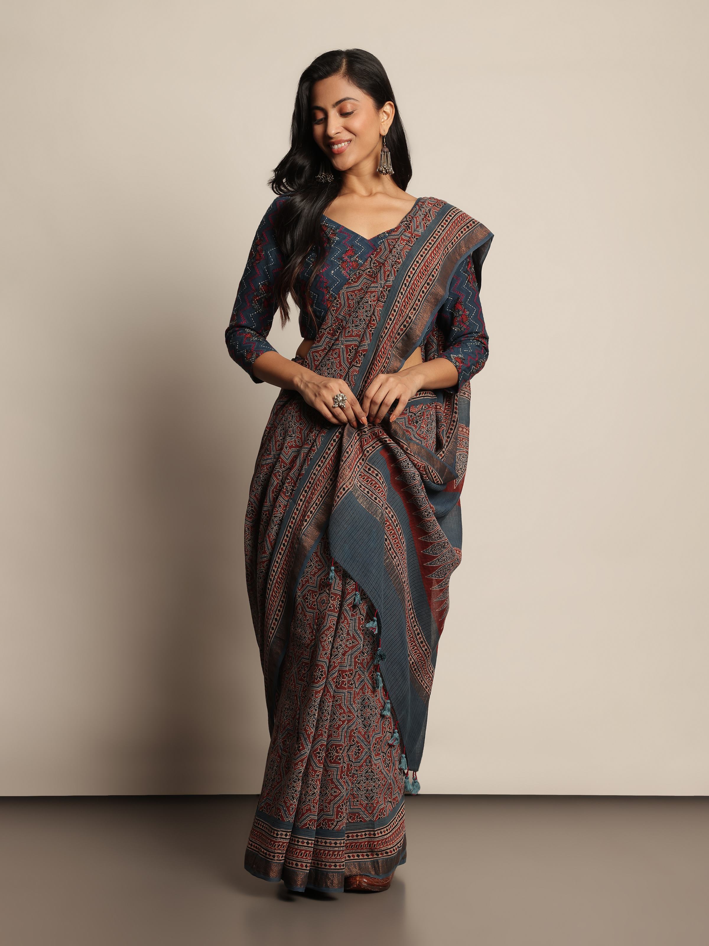 Angled view of blue Maheshwari Ajrakh block printed saree showing print details and fabric texture.