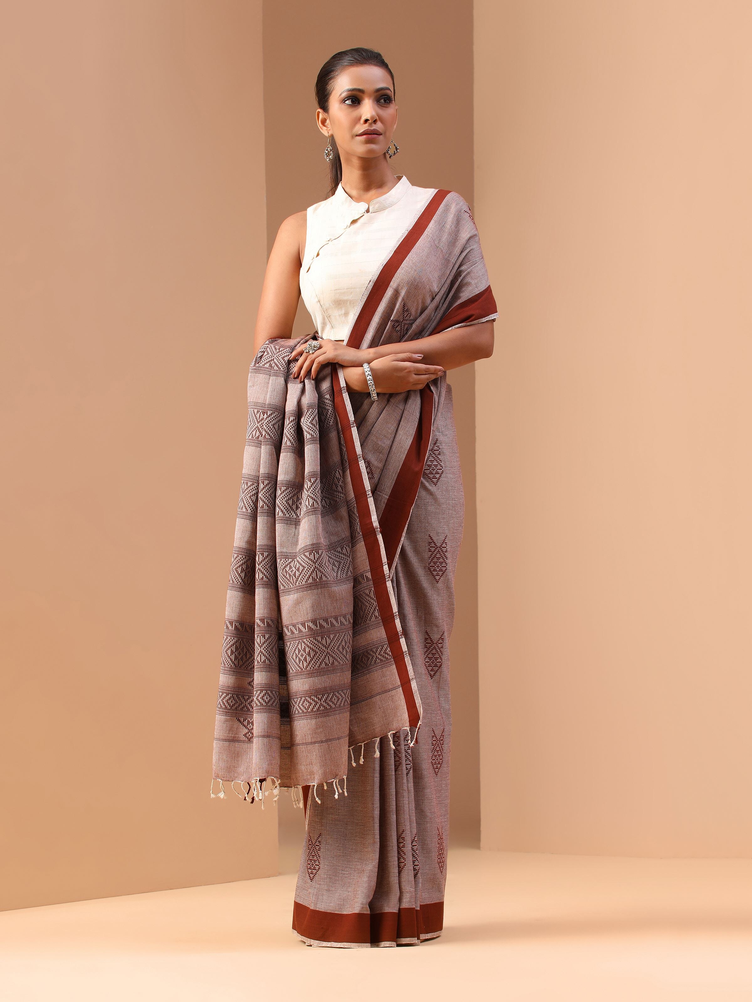 Lifestyle image of brown cotton extra-weft saree worn with ethnic accessories