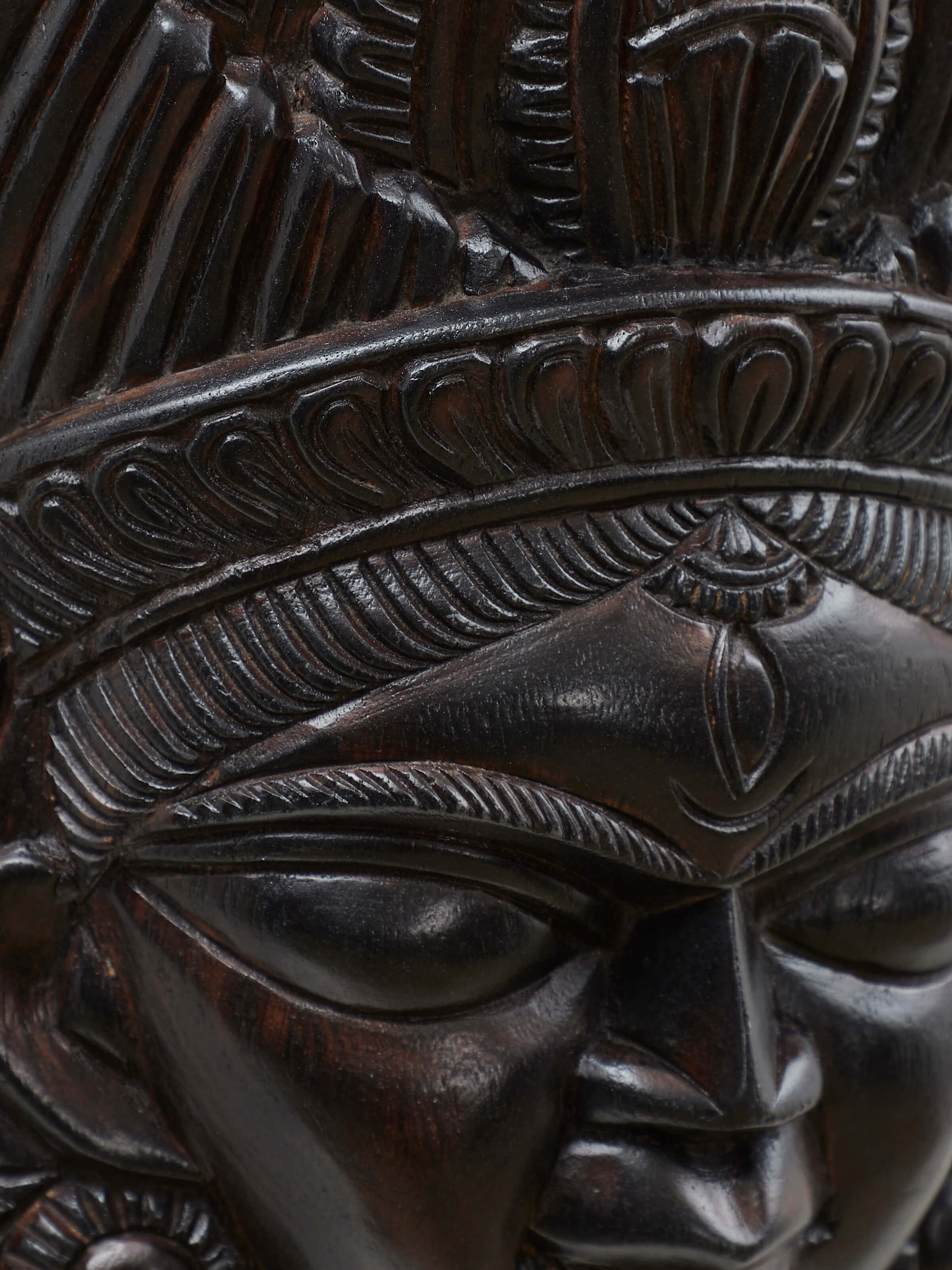 Angled view of Kushmandi goddess wall mask showing sculpted details