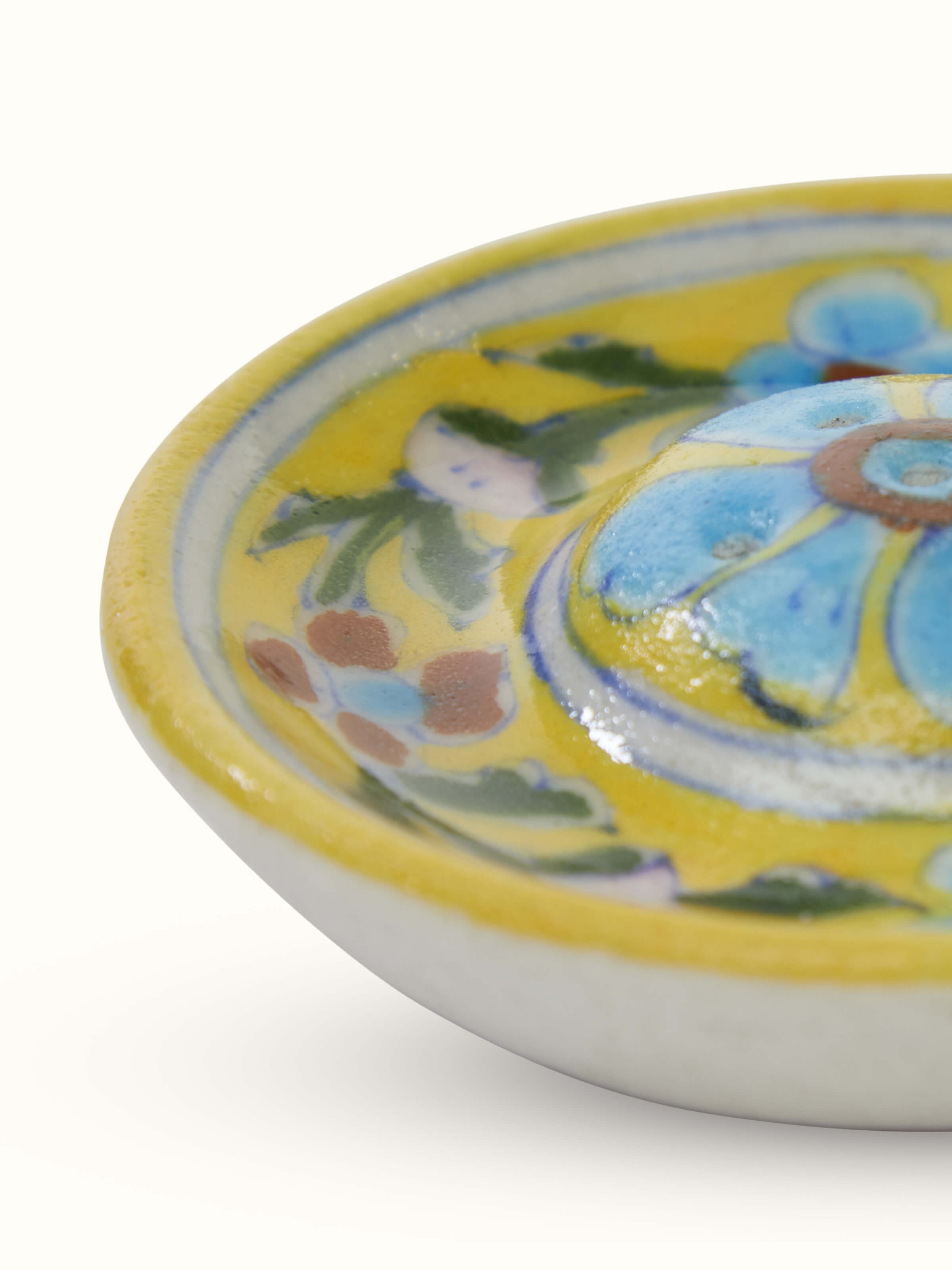 Detail close-up of ceramic floral incense stick holder showing painted design