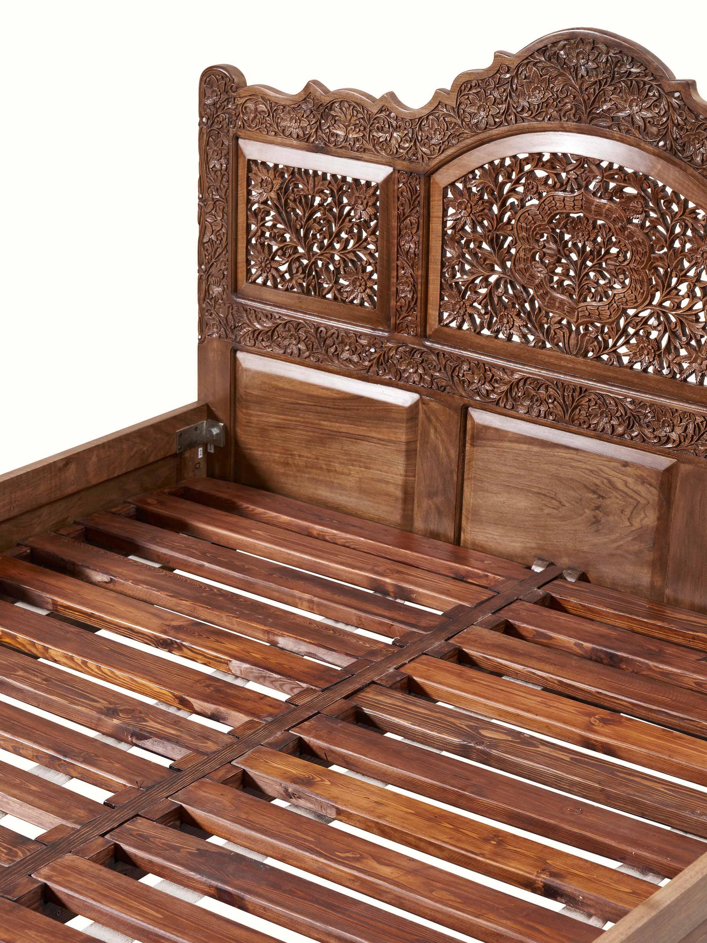 Detailed shot of the headboard of carved walnut wood queen size bed, showcasing the intricate carvings and texture.