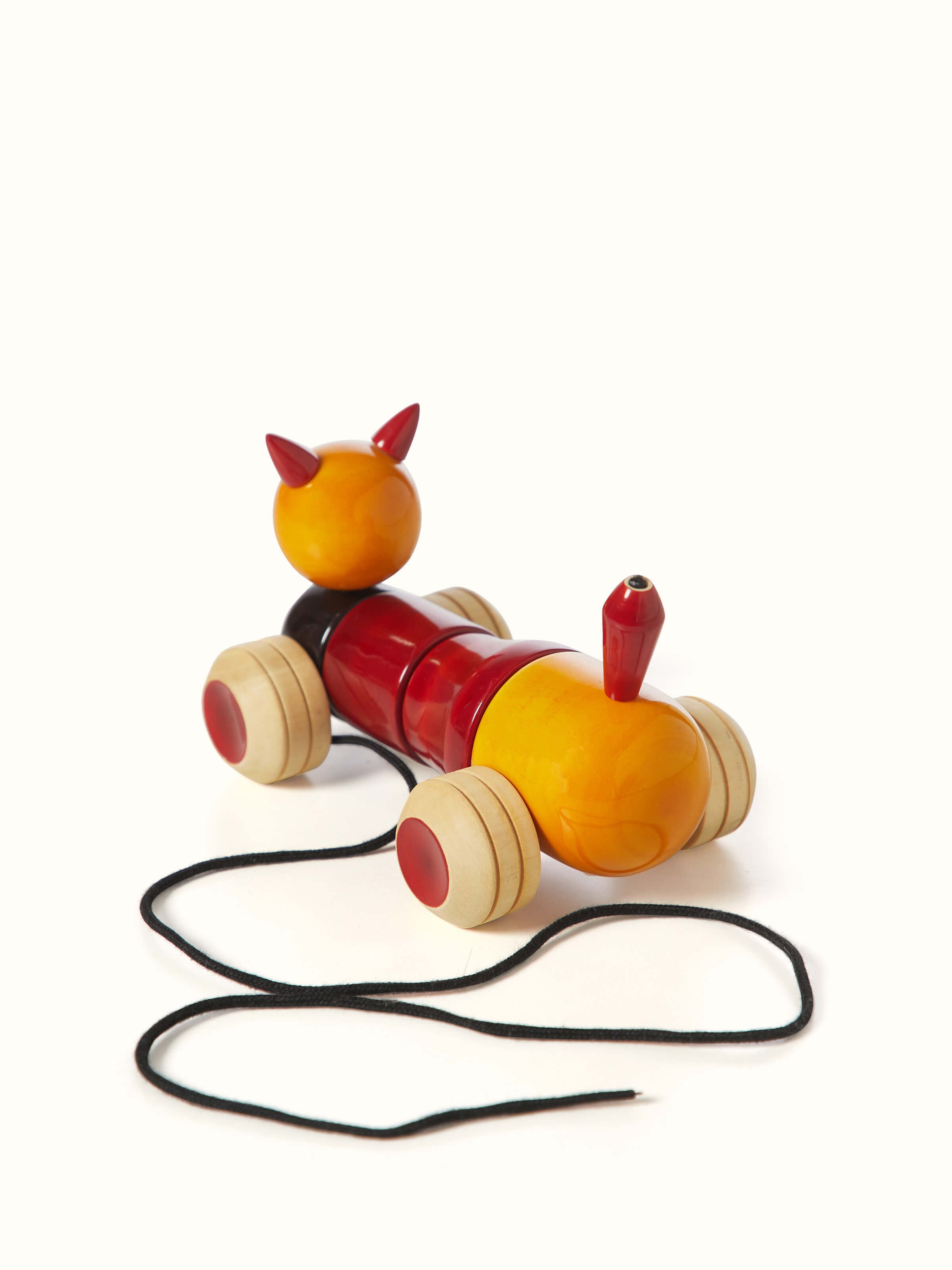 Angled view of Channapatna ivory wood bovow yellow toy, featuring intricate designs and smooth texture.