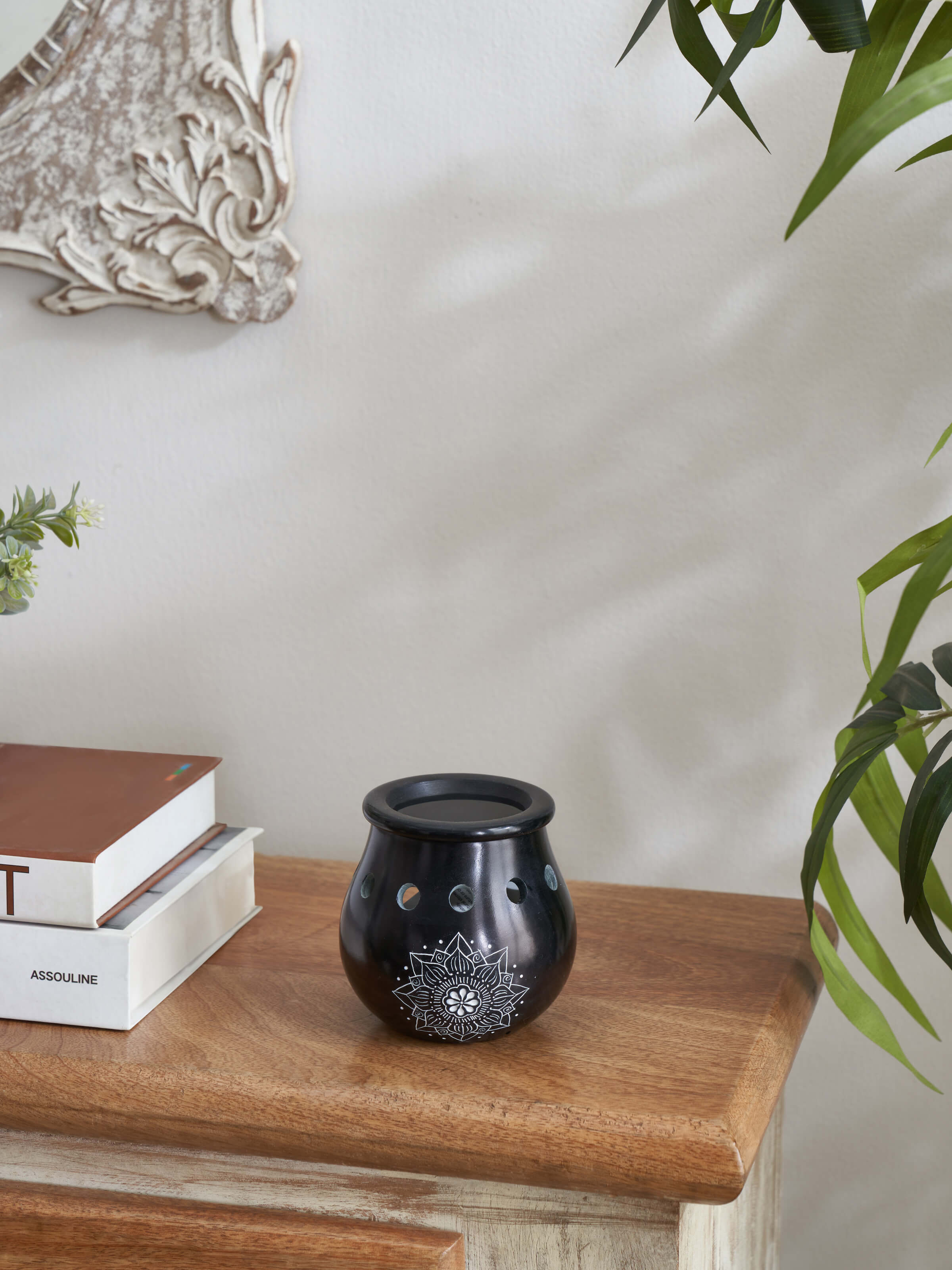 Side view of Carved Stone Diffuser in black, showcasing intricate design and smooth texture.