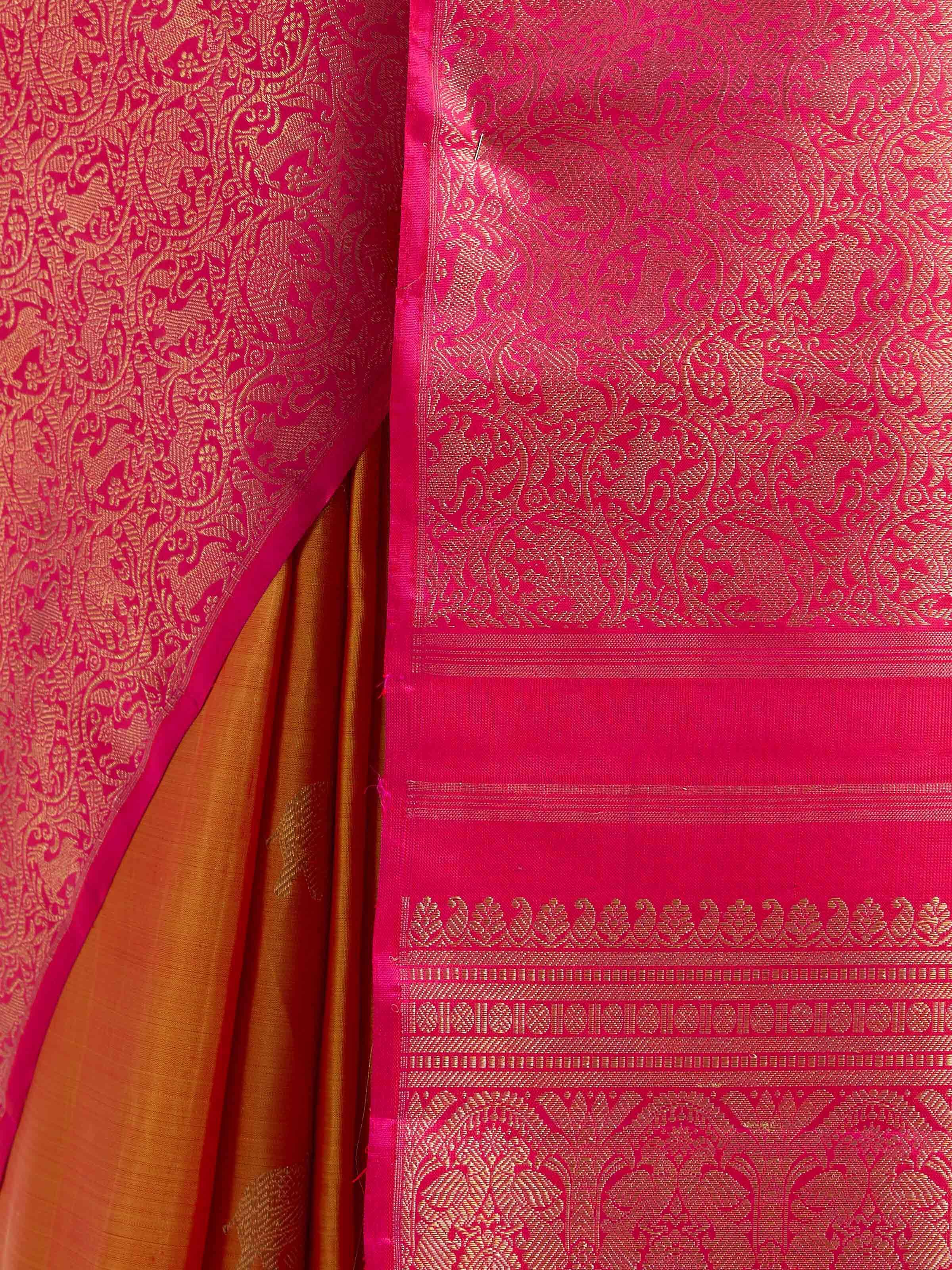 Detail view of orange silk Kancheepuram saree showing zari work