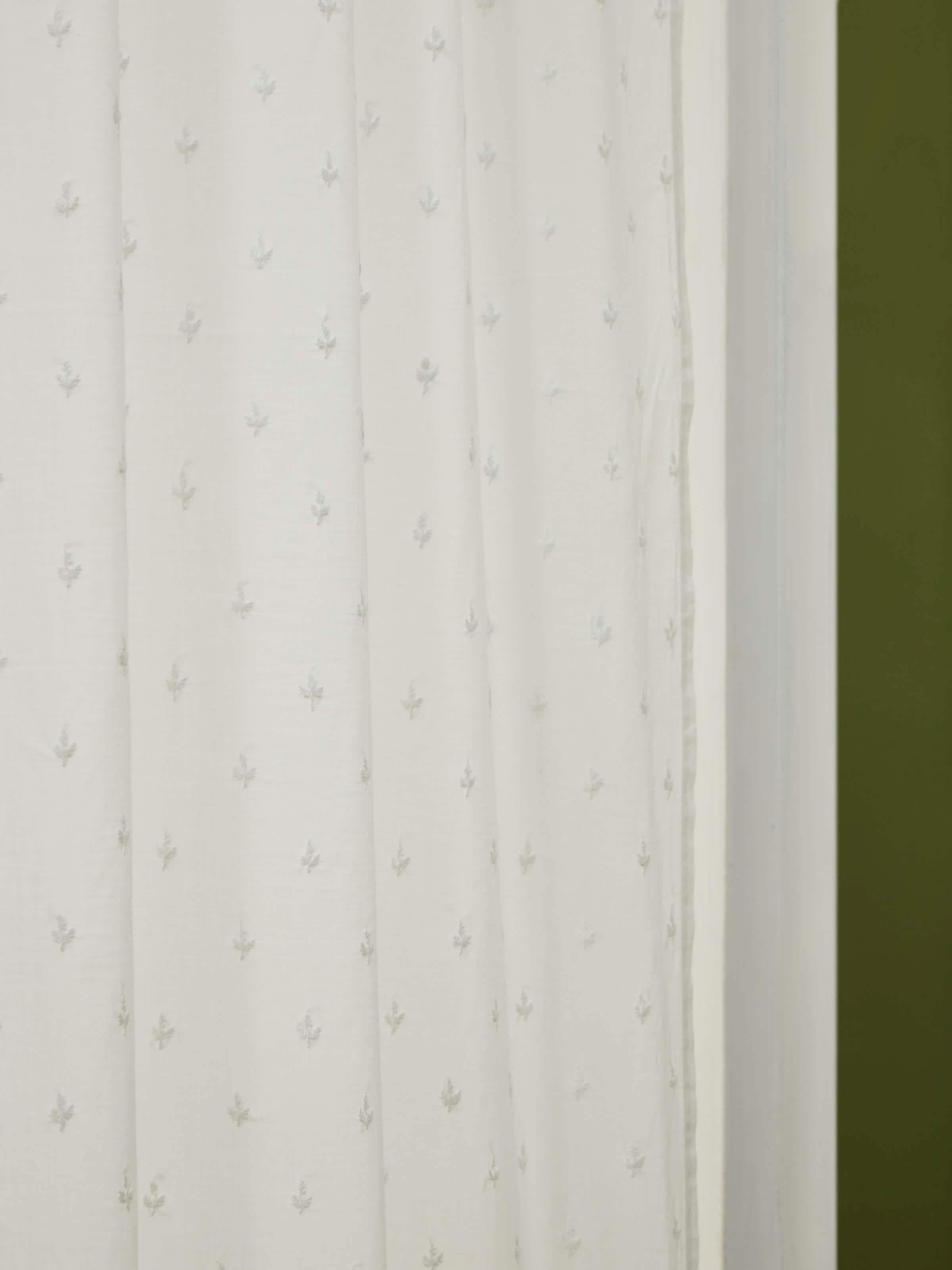 Close-up of trellis embroidery detail on cotton Chikankari sheer curtain in white.