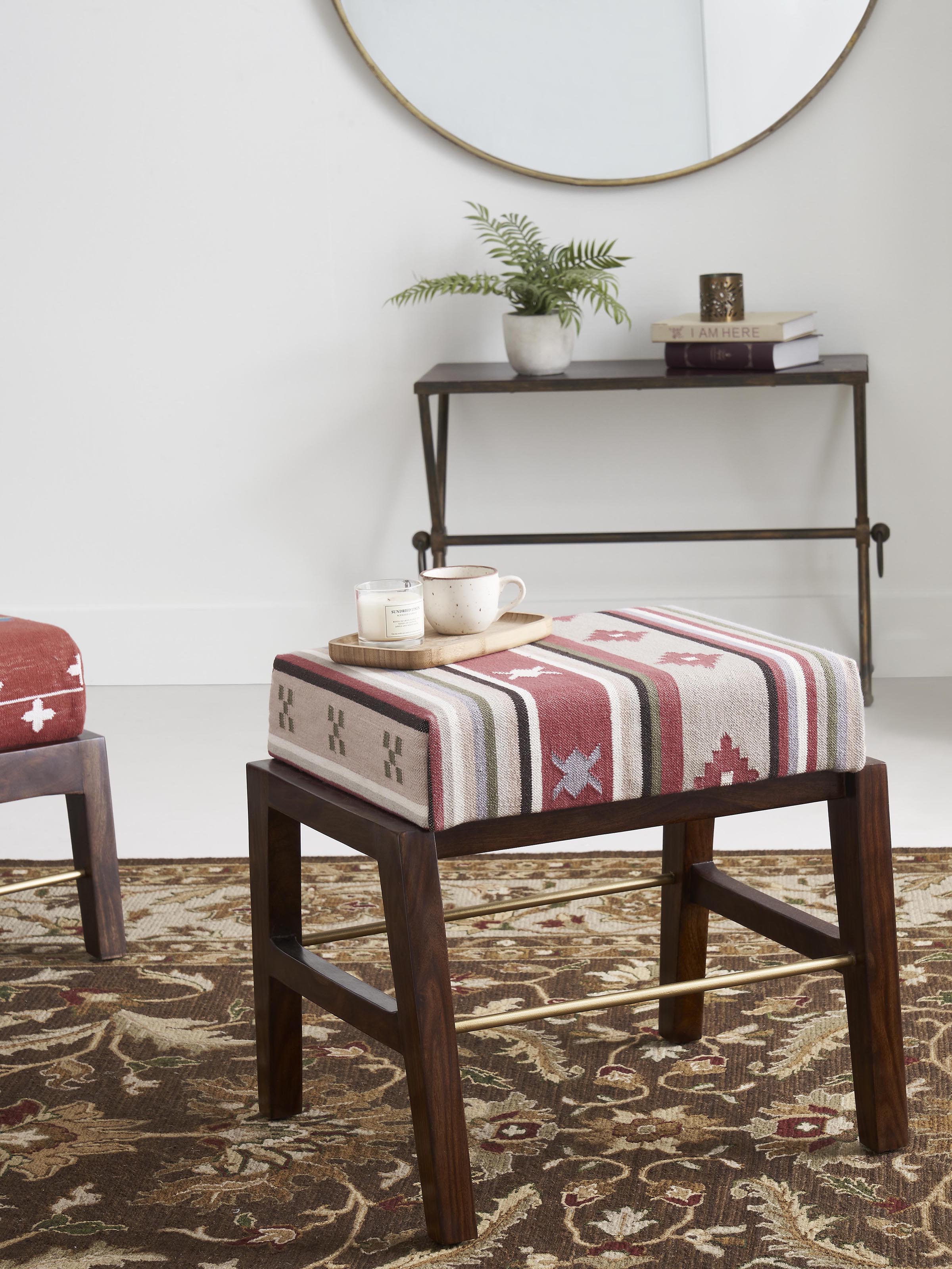 Side view of the Panja Dhurrie upholstered Sheesham wood ottoman with metal connector, highlighting the ottoman's profile and fabric.
