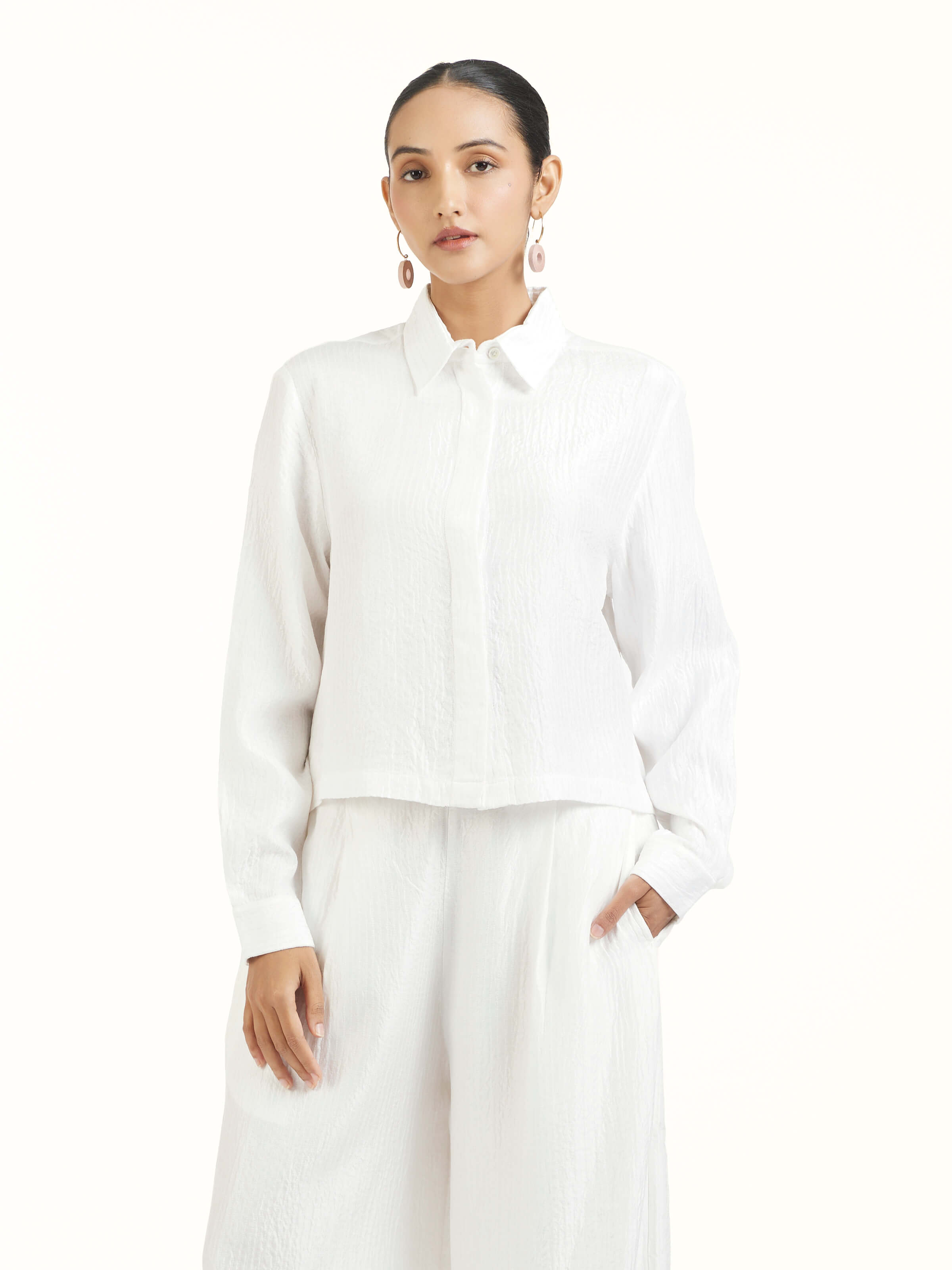 Angled view of ivory quilted silk pants highlighting quilted texture