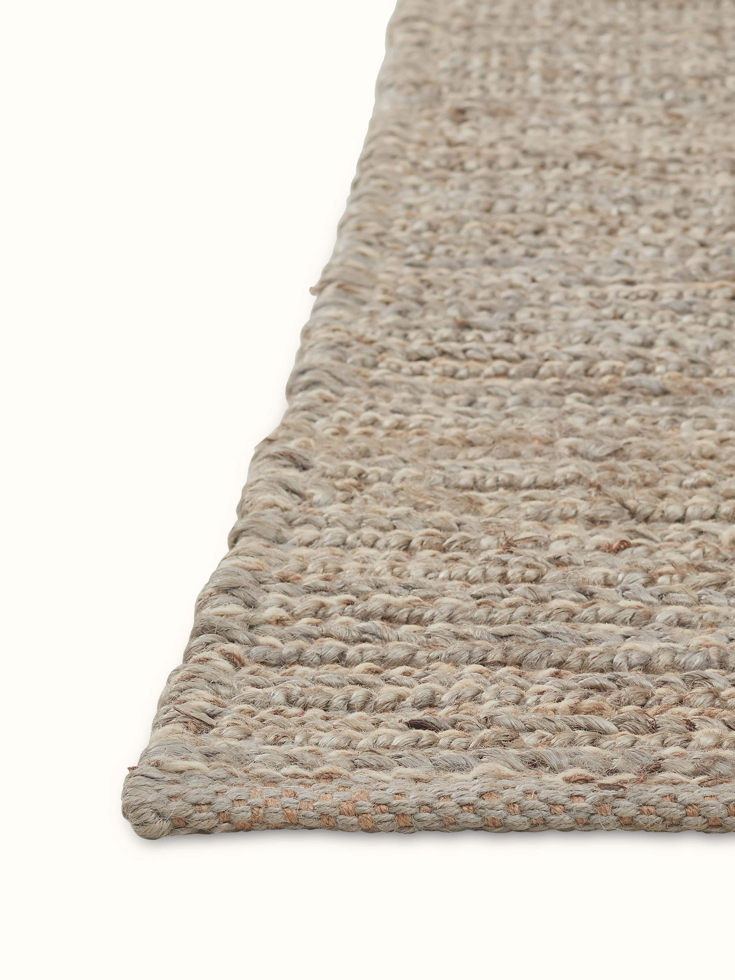 Angled view of Grey Jute & Wool Rug highlighting natural fiber texture and handcrafted finish