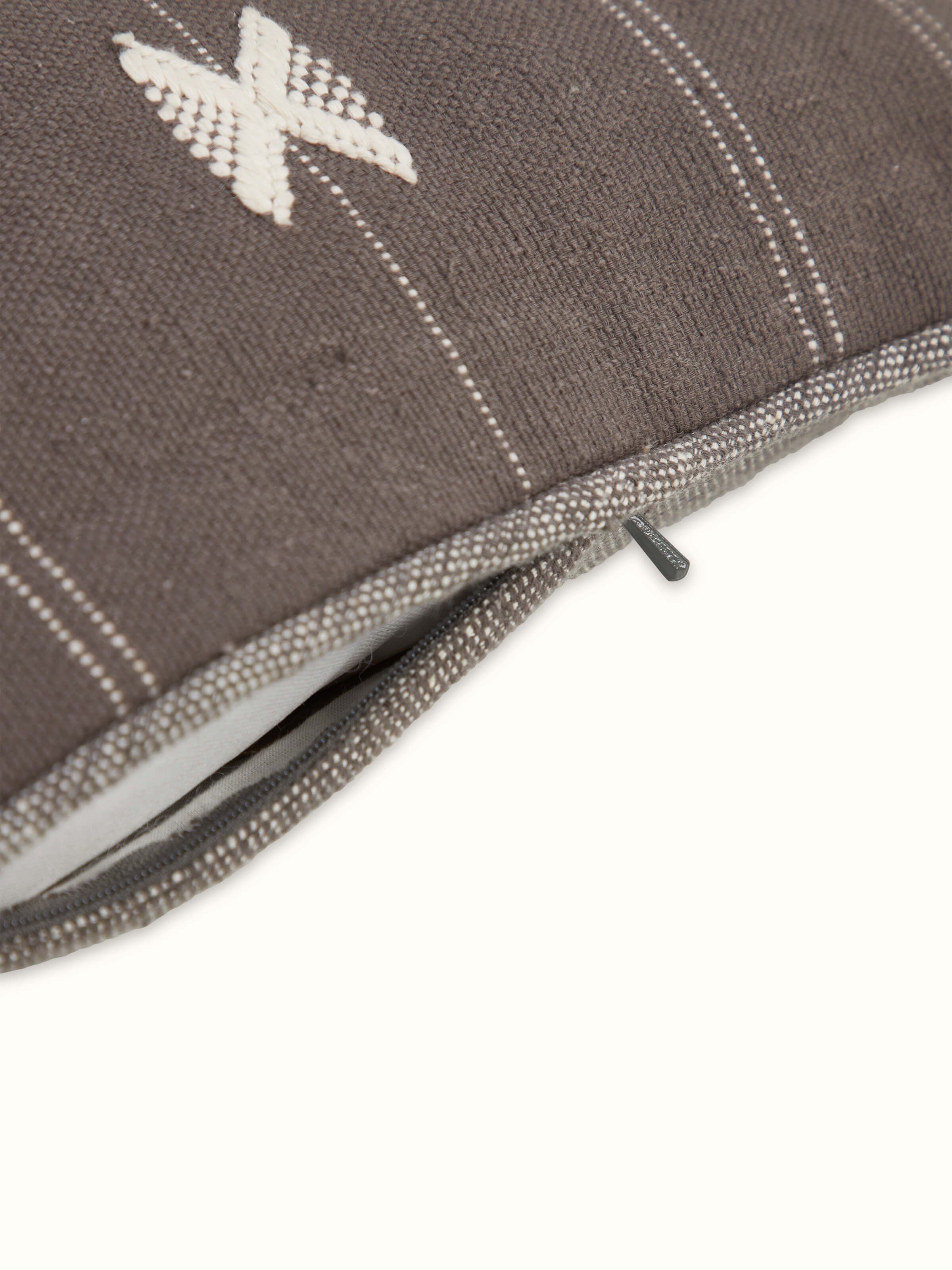 Angled shot emphasizing the handwoven craftsmanship and the subtle cotton texture