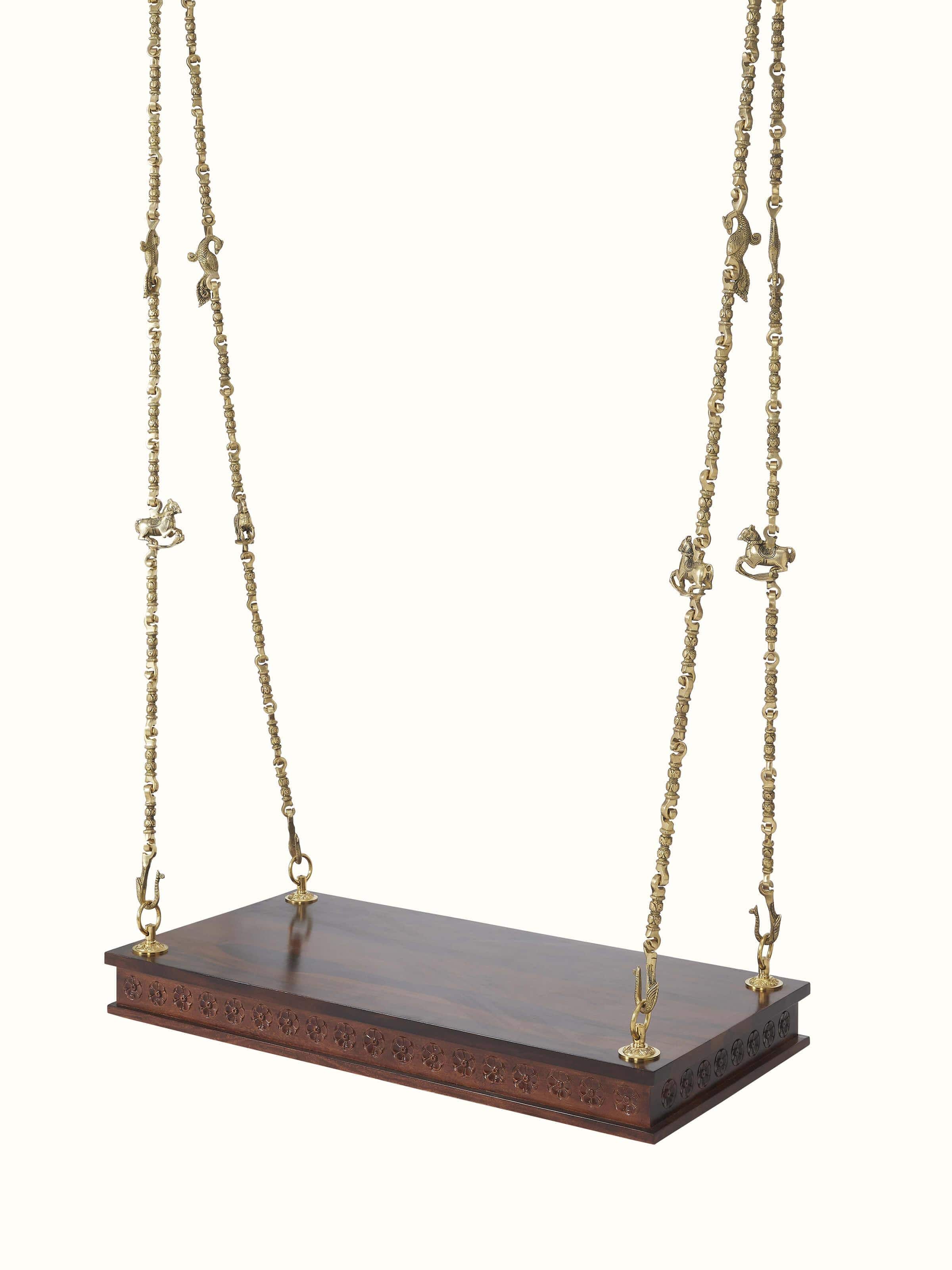 Side view of the Sheesham wood and brass swing, showcasing its detailed carvings and sturdy frame.