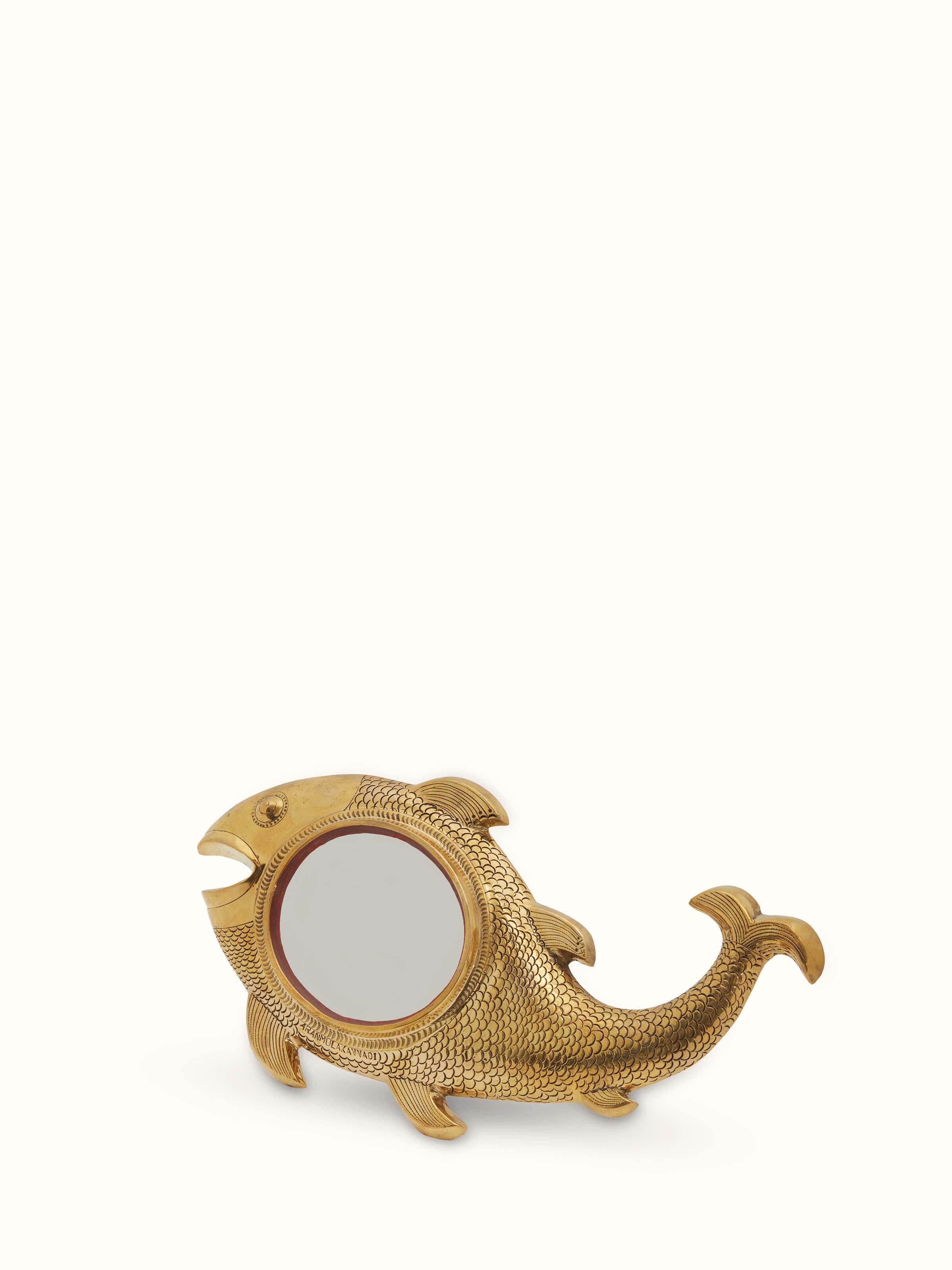 Side view of Aranmula kannadi brass mirror highlighting its reflective surface and detailed border.