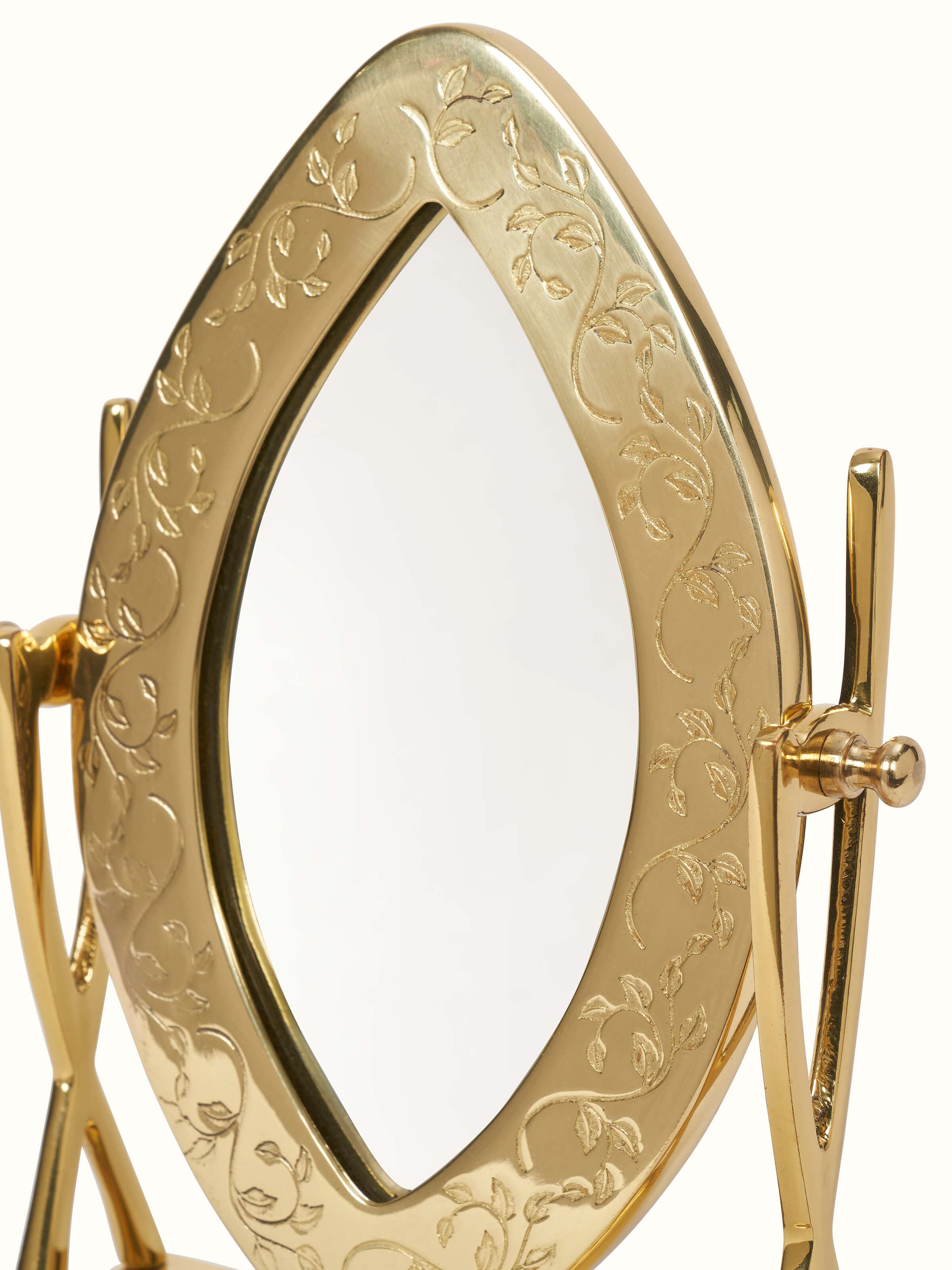 Close-up of brass-plated table mirror with a focus on the reflective surface