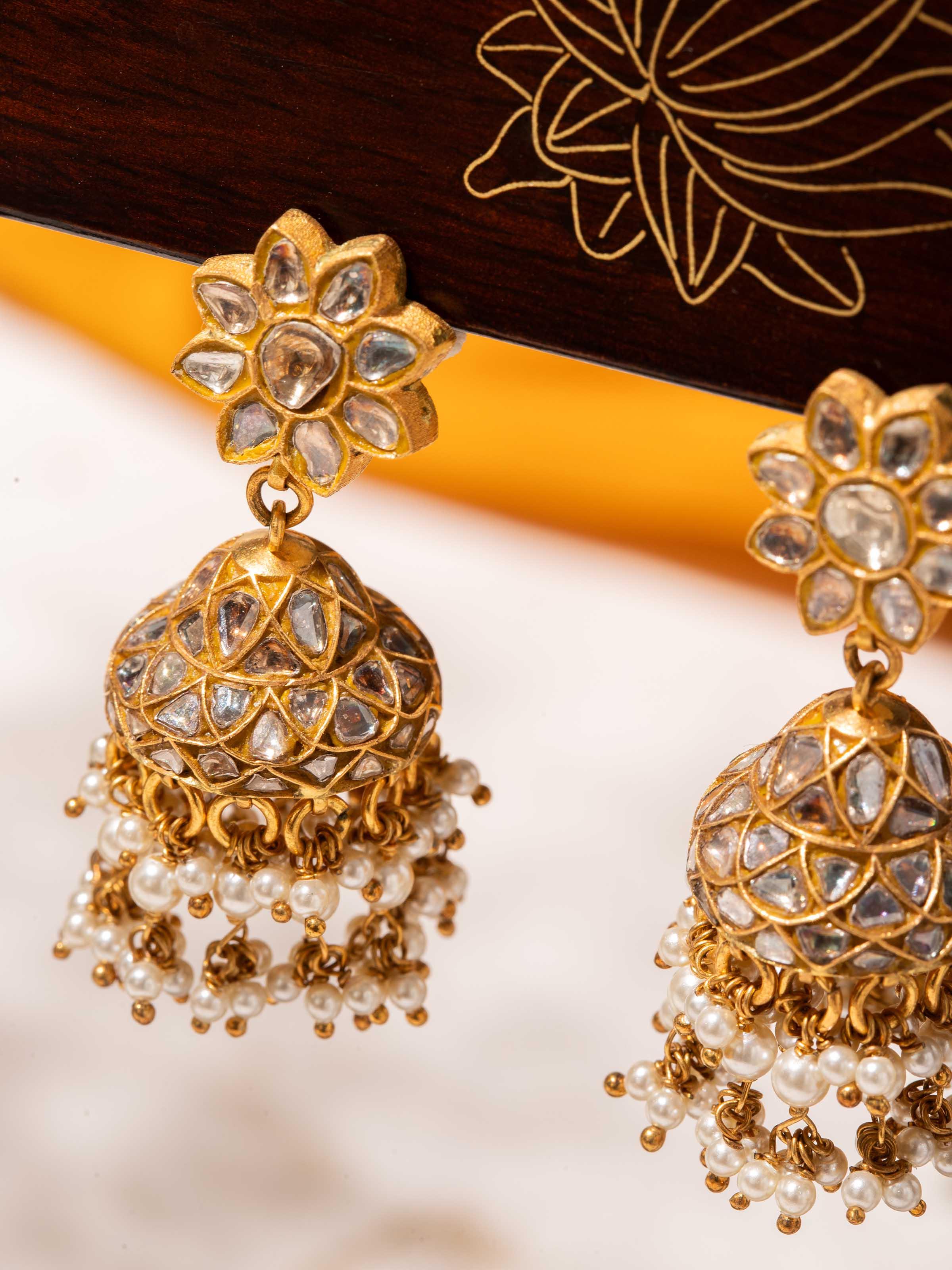 Overhead angle of gold jhumka showcasing symmetrical bell-shaped structure