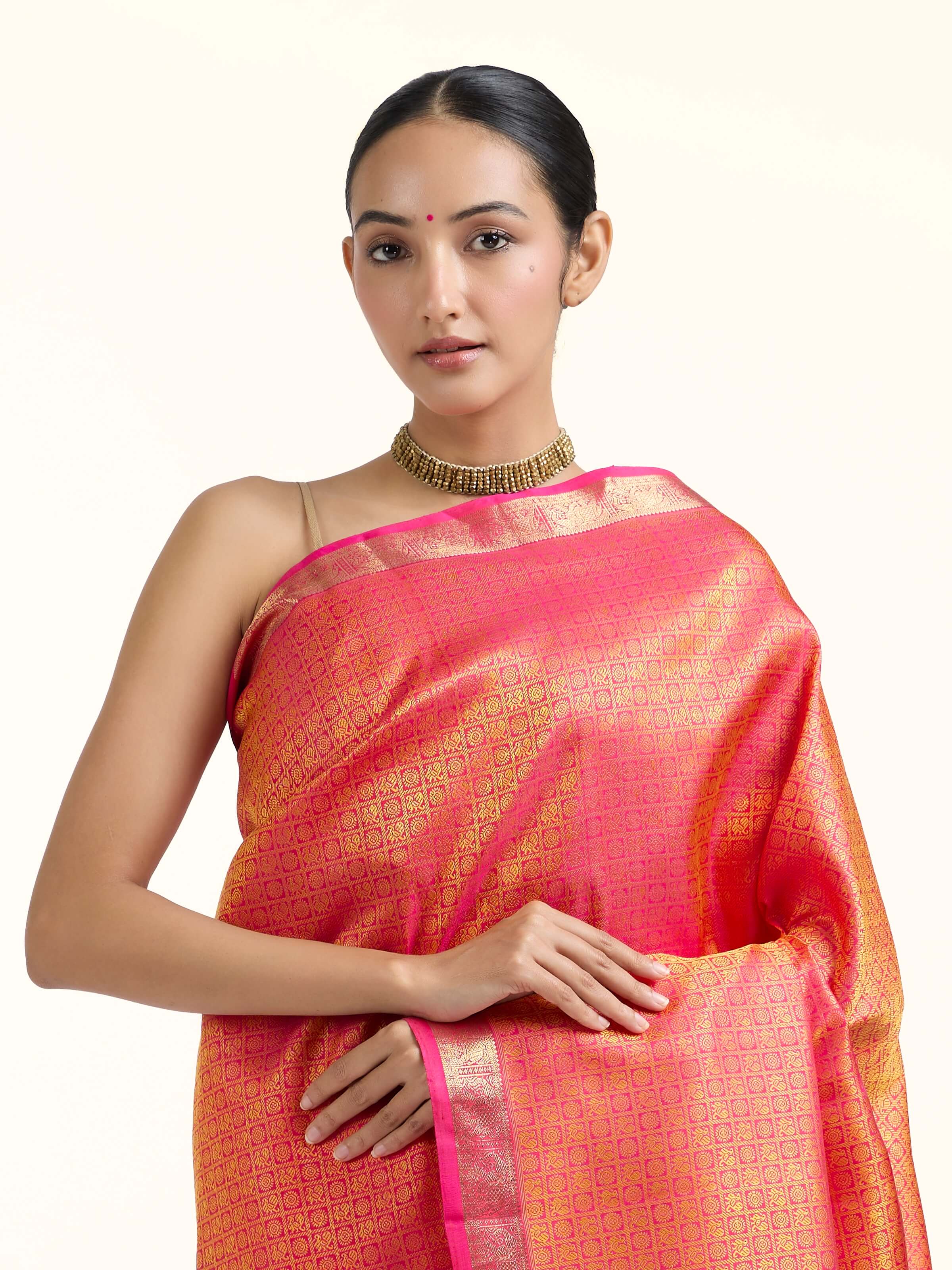 Angled view of orange silk Kancheepuram saree highlighting traditional weave and sheen