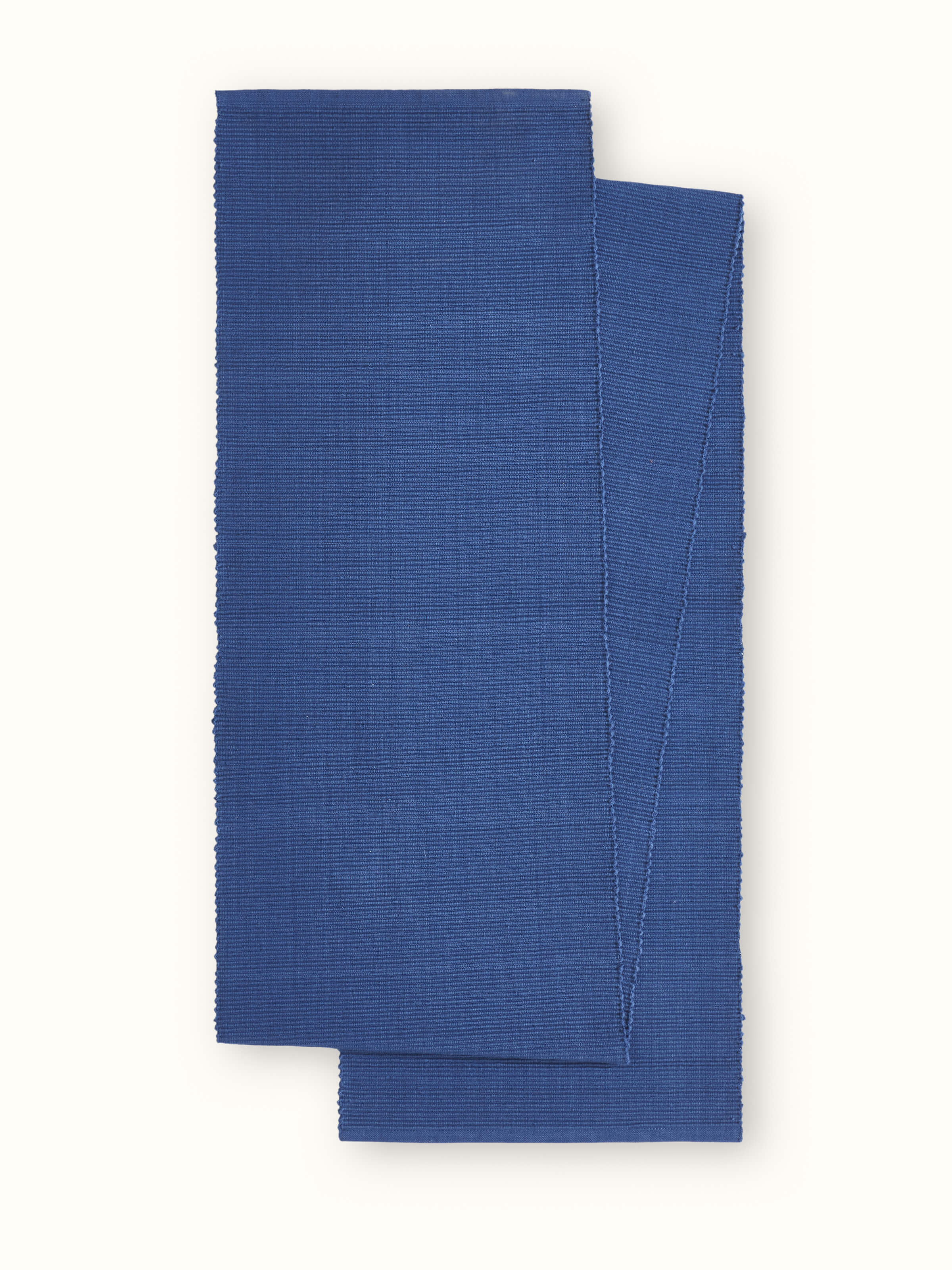 Front view of Vastav indigo solid cotton handloom table runner neatly spread on a wooden table for four.