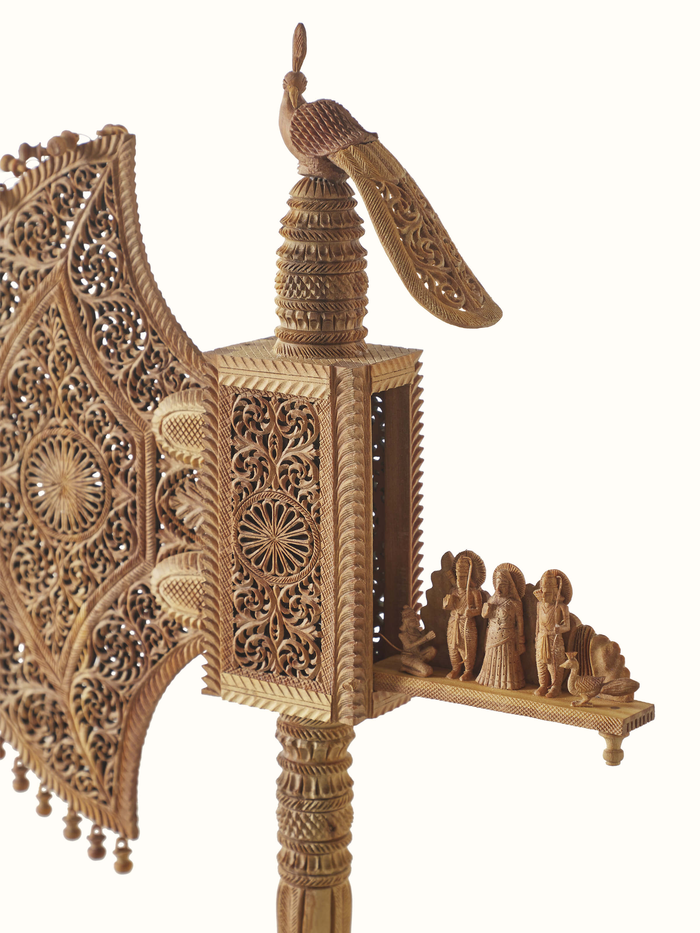 Angled view of Bilara carved sandalwood jaali fan sculpture emphasizing craftsmanship