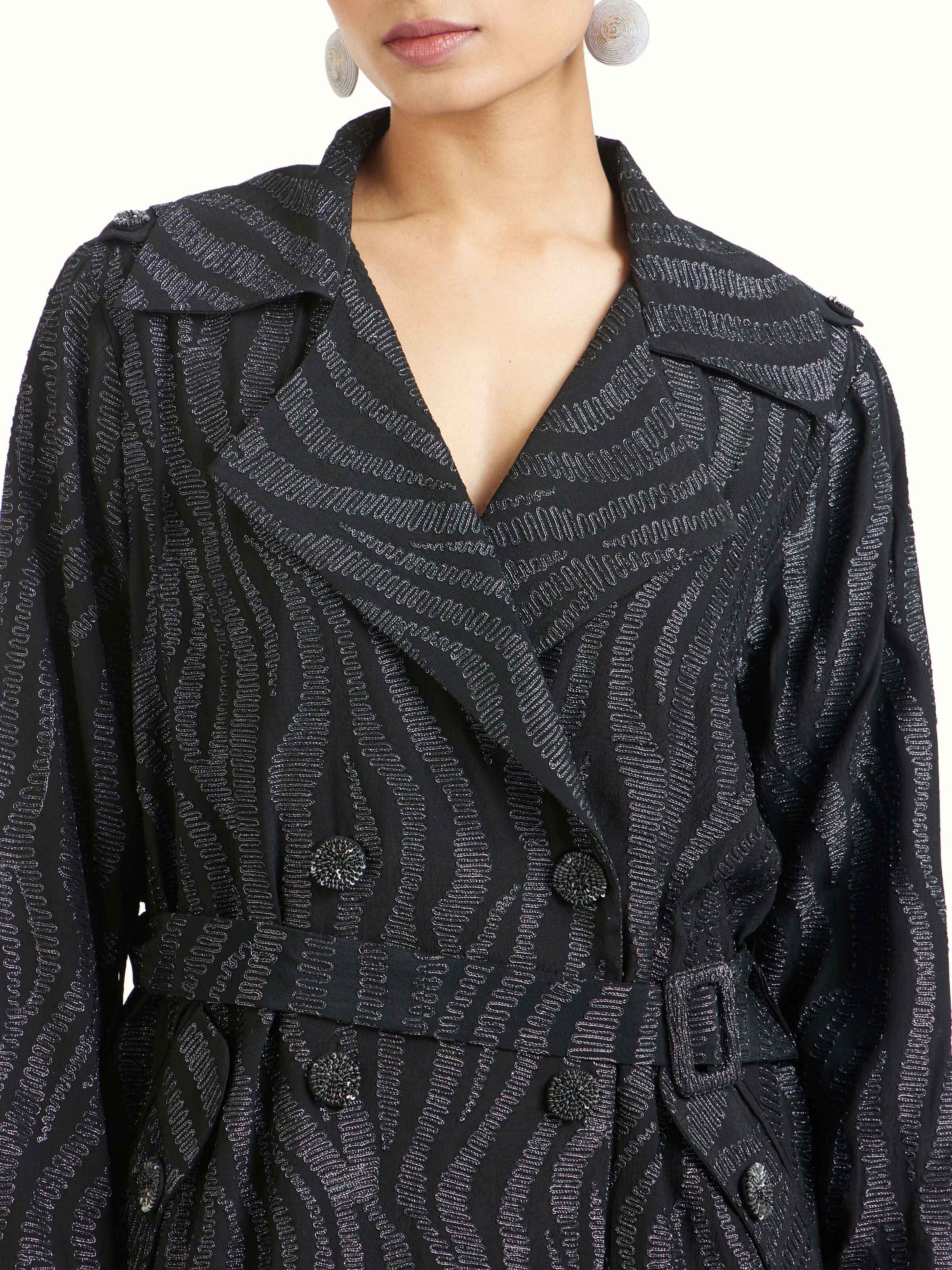 Detail view of black aari hand embroidered trenchcoat showcasing fine embroidery craftsmanship