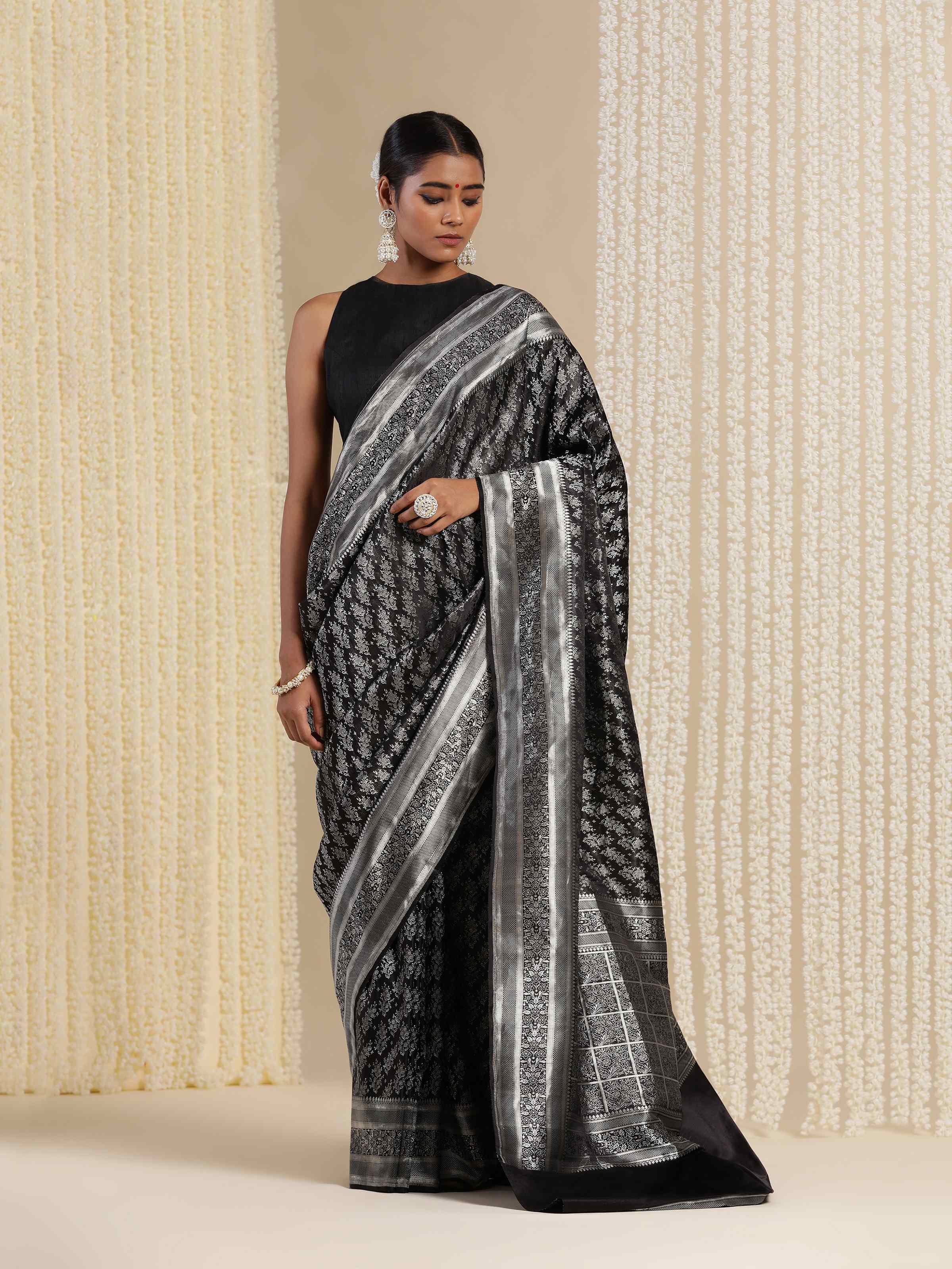 Lifestyle shot of Black Silk Satin Tanchoi Banarasi Saree draped elegantly with contrast zari work.