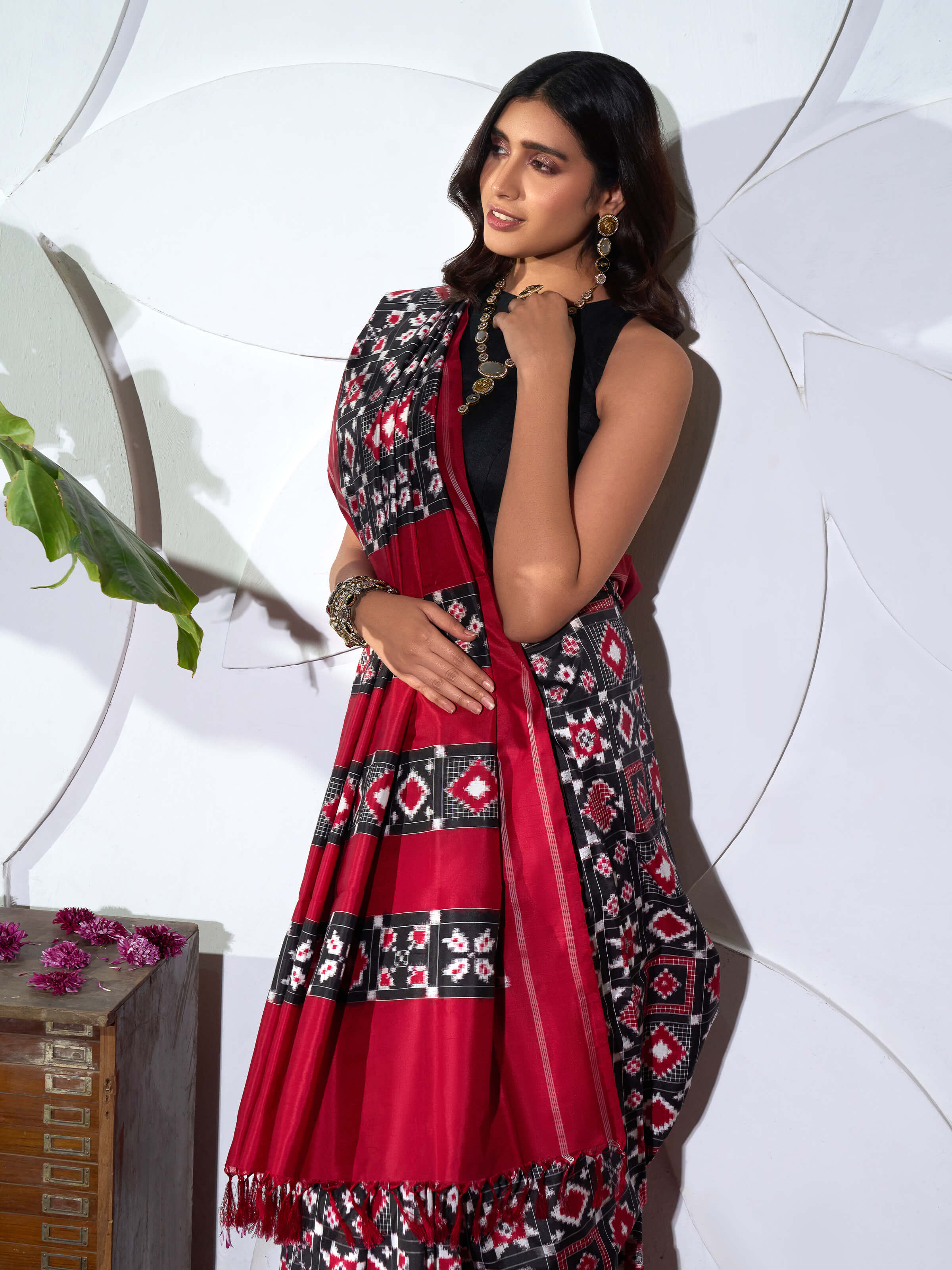 Angled view of red silk Telia Rumal double ikat saree highlighting resist-dyed weave and sheen