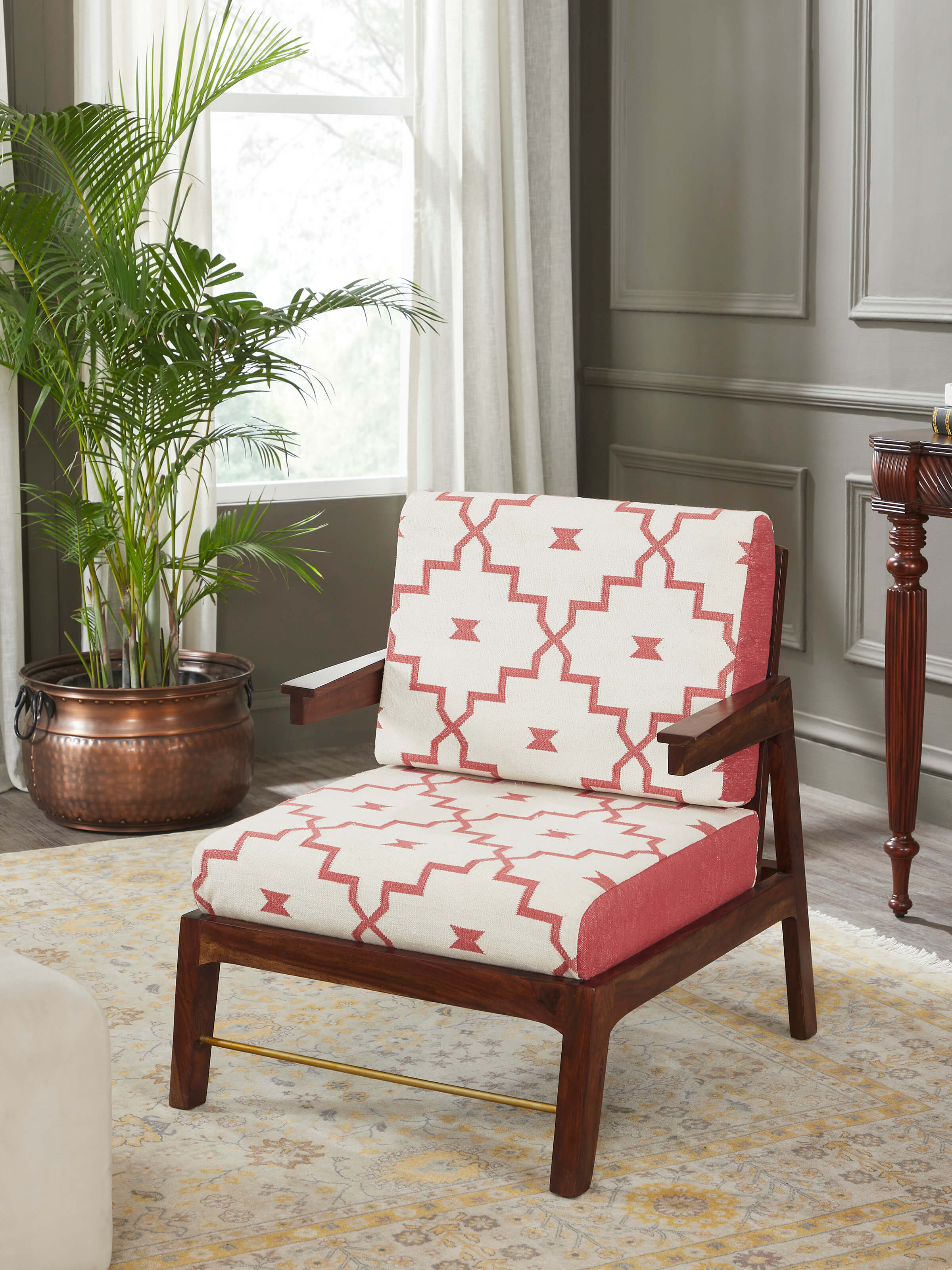 Lifestyle shot of handloom dhurrie upholstered Sheesham wood armchair in a contemporary living room setting