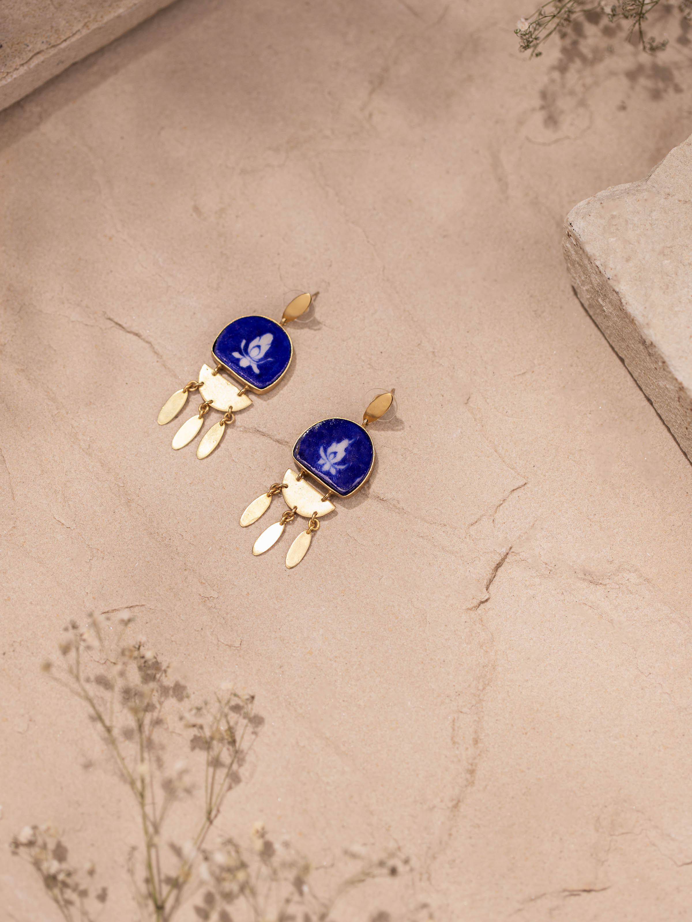 Close-up view of blue pottery drop earrings highlighting detailed craftsmanship