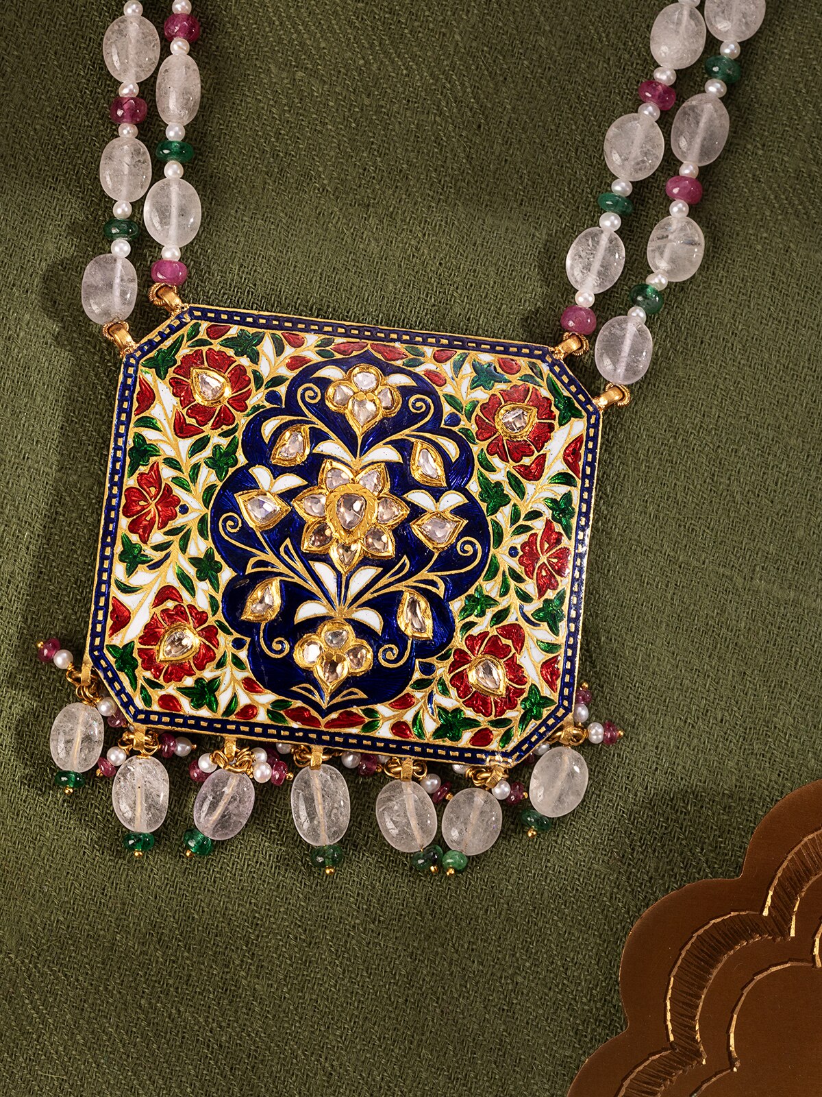 Close-up detail of Jaipur Meenakari gold pendant revealing fine craftsmanship and colourful hand-painted detailing.