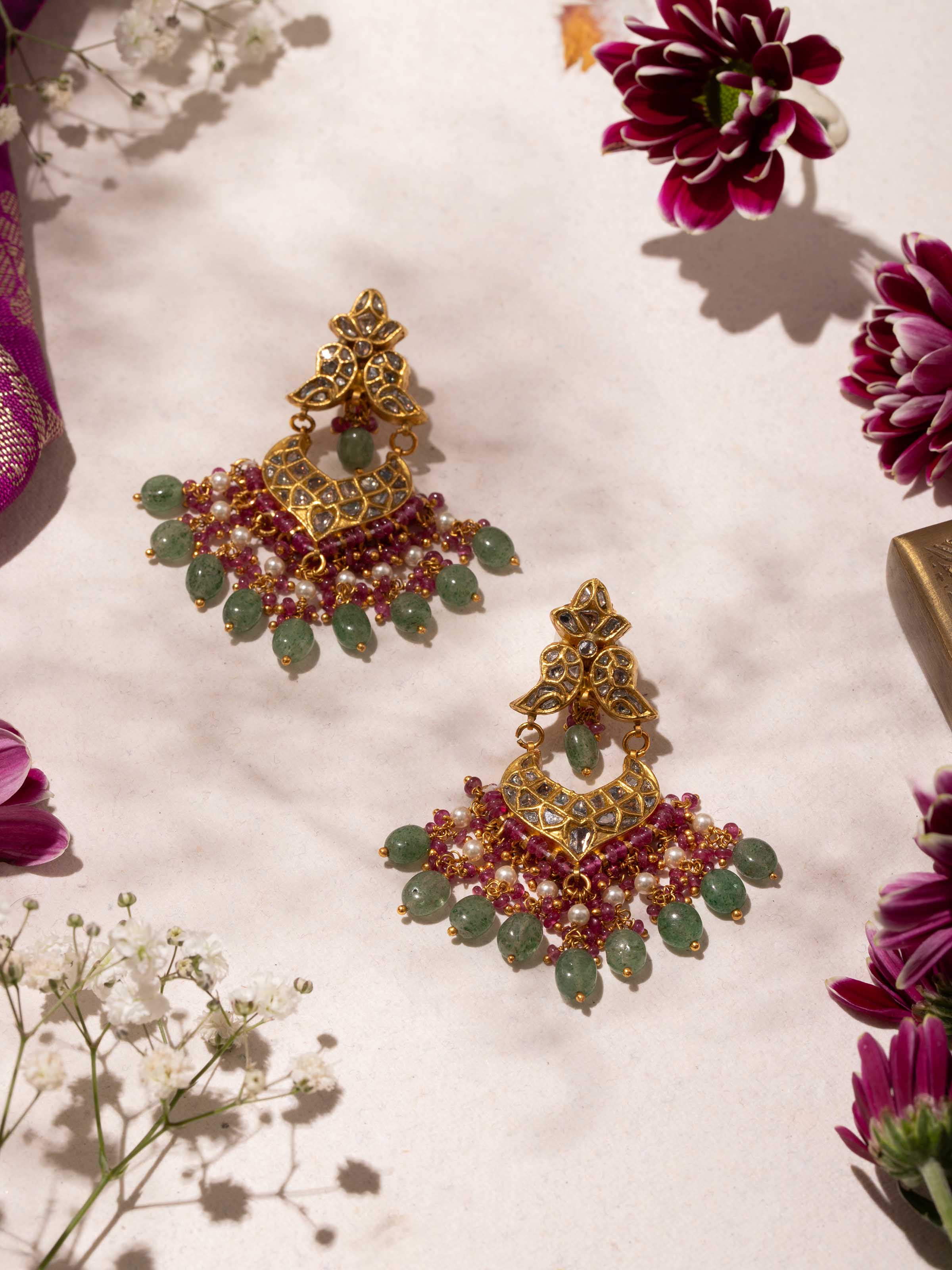Side angle highlighting intricate design of Thappa gold drop earrings