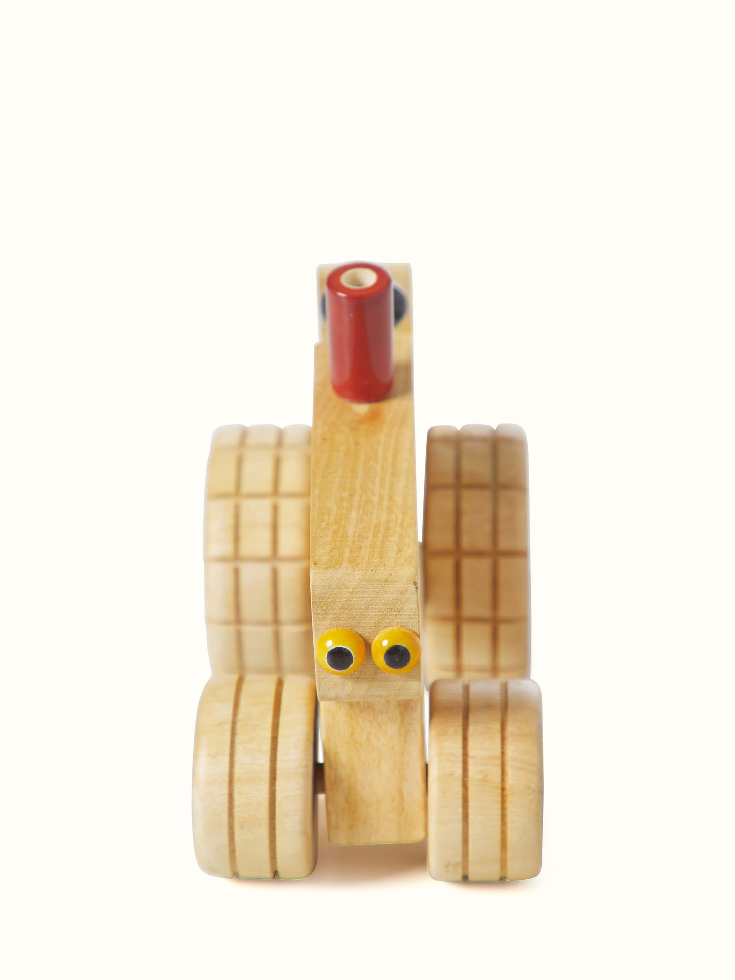 Front view of white Channapatna ivory wood tractor toy demonstrating its intricate design