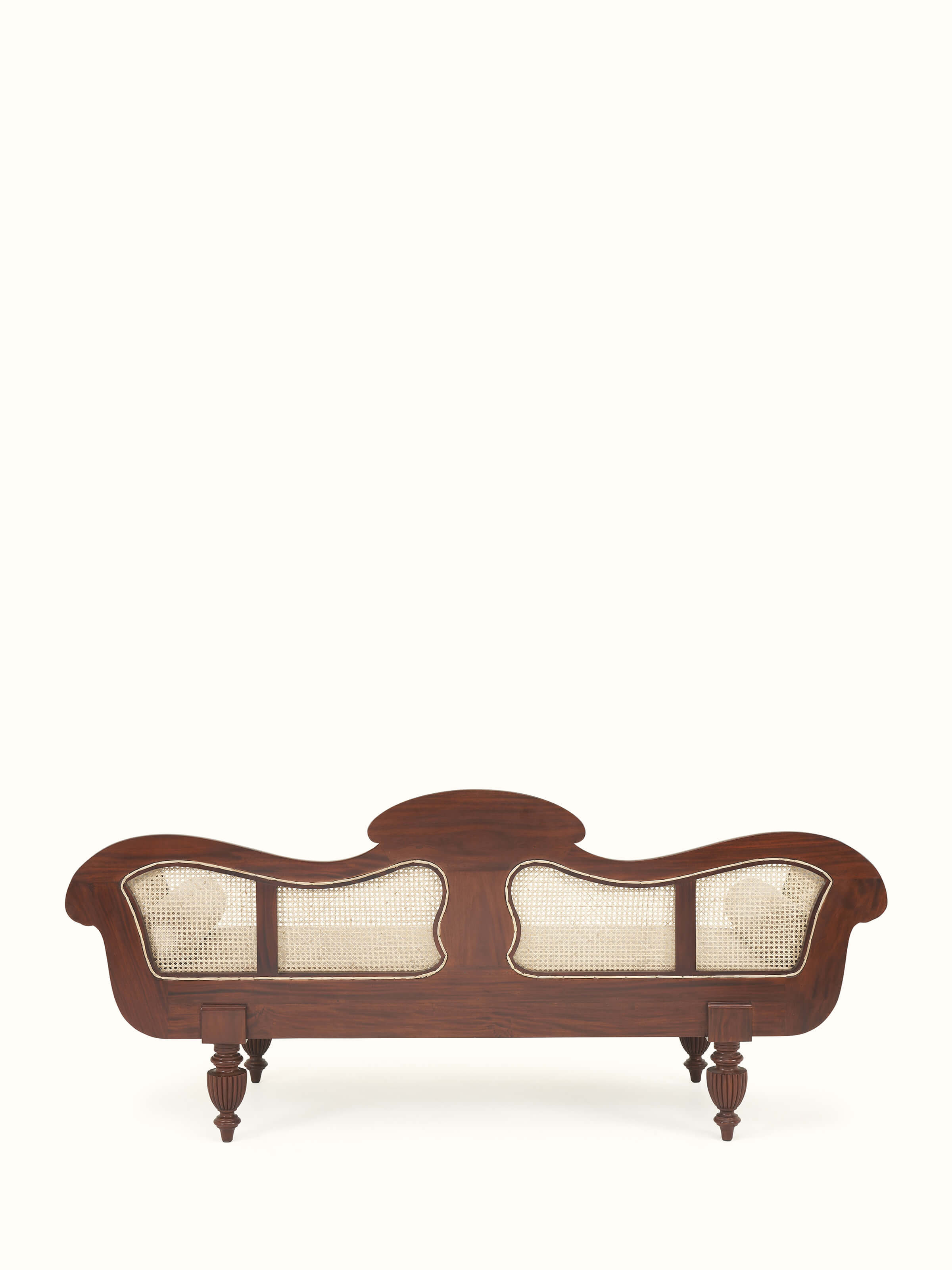 Back view of upholstered Mahogany wood and cane sofa revealing wooden structure and cane backrest