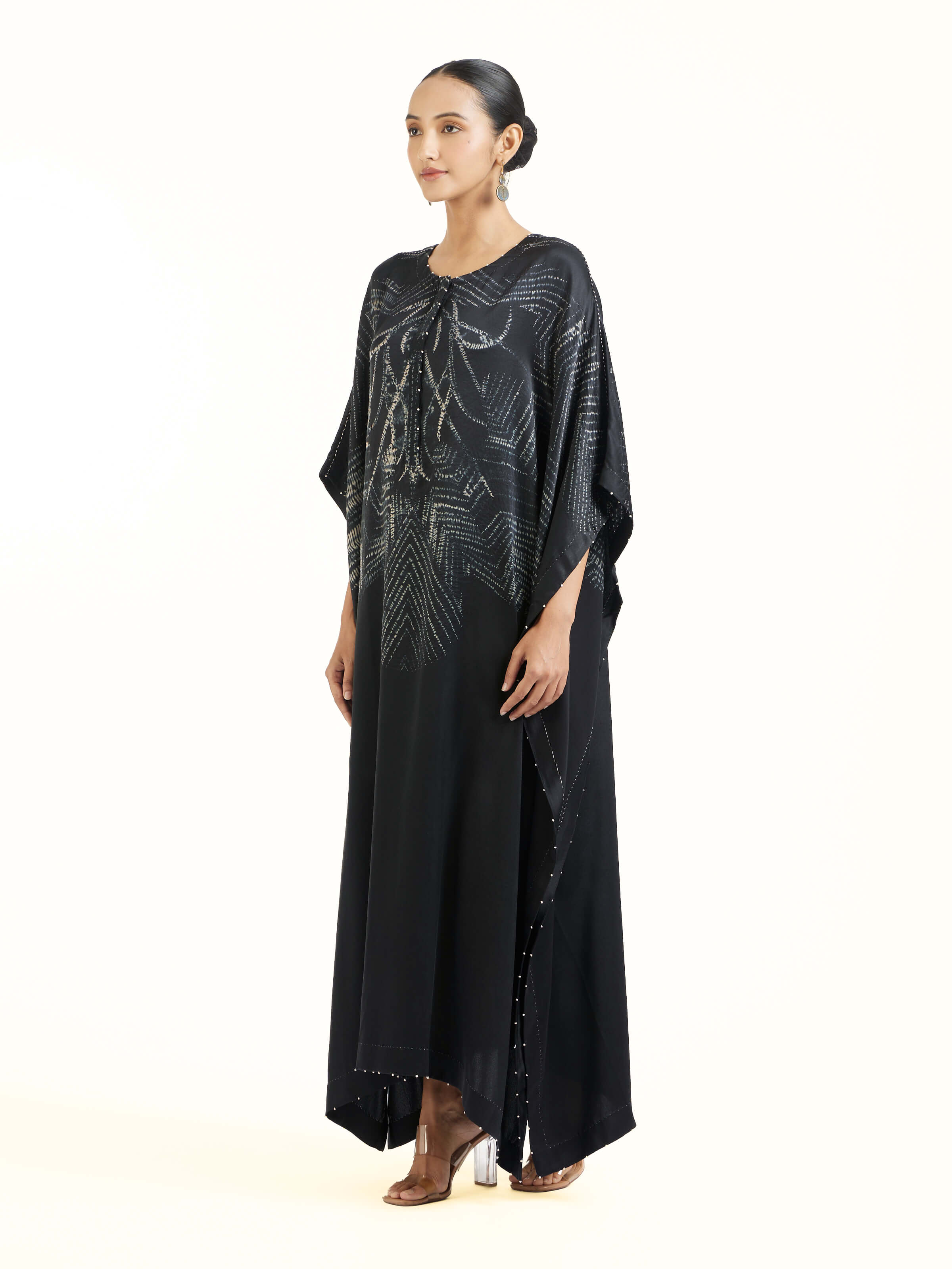 Side view of black satin shibori kaftan showcasing relaxed silhouette