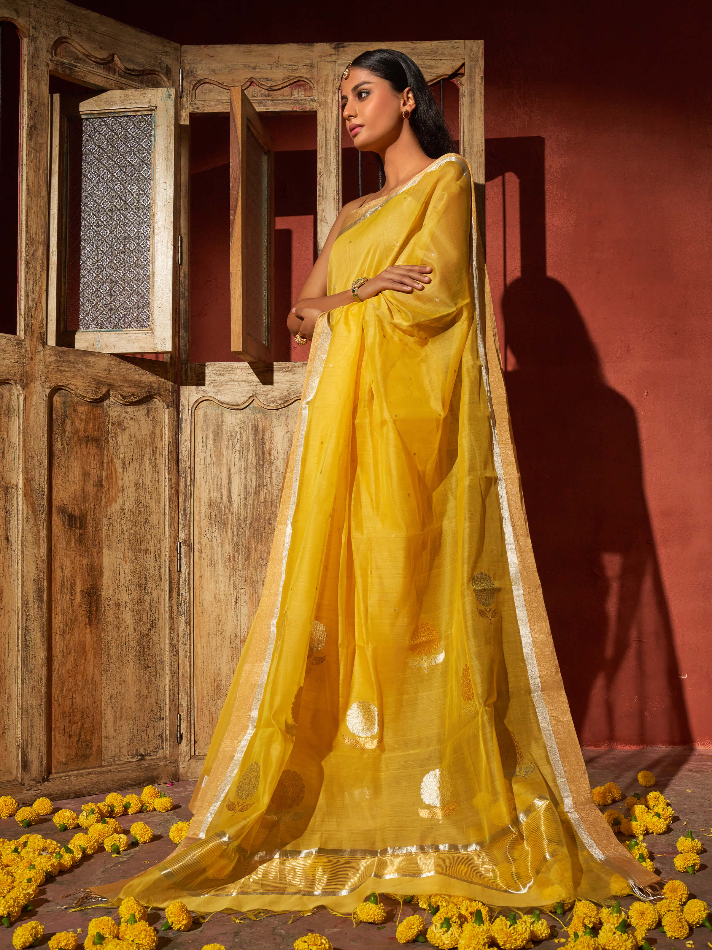 Angled view of yellow mulberry silk cotton Chanderi saree highlighting woven motifs