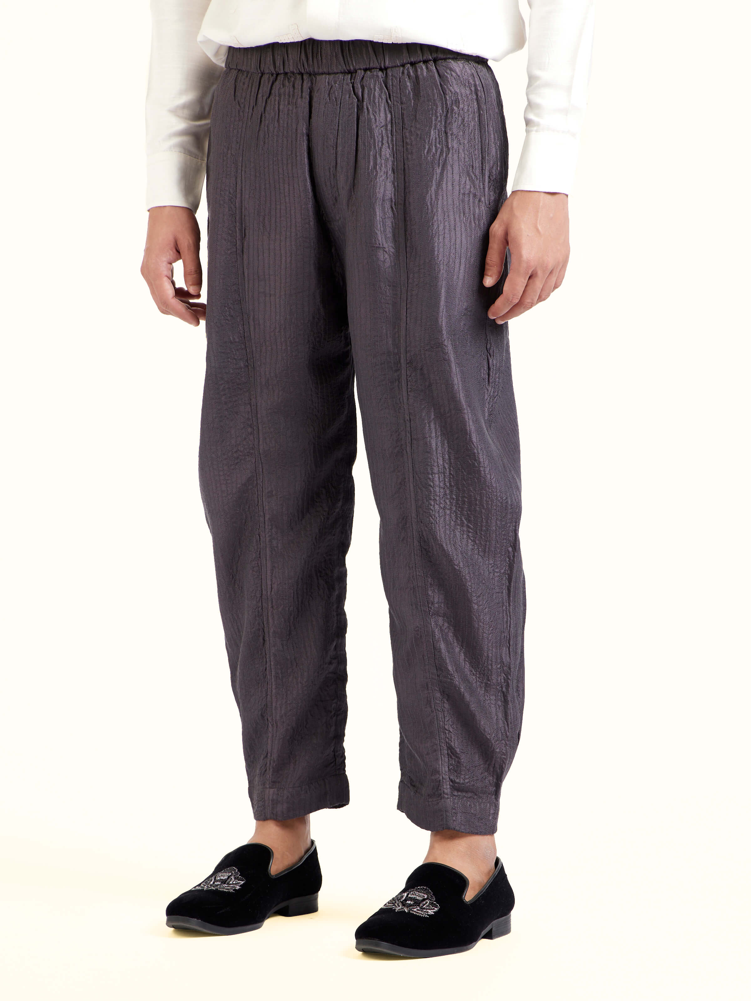 Angled view of grey straight quilted tulip pure silk pants emphasizing quilted texture