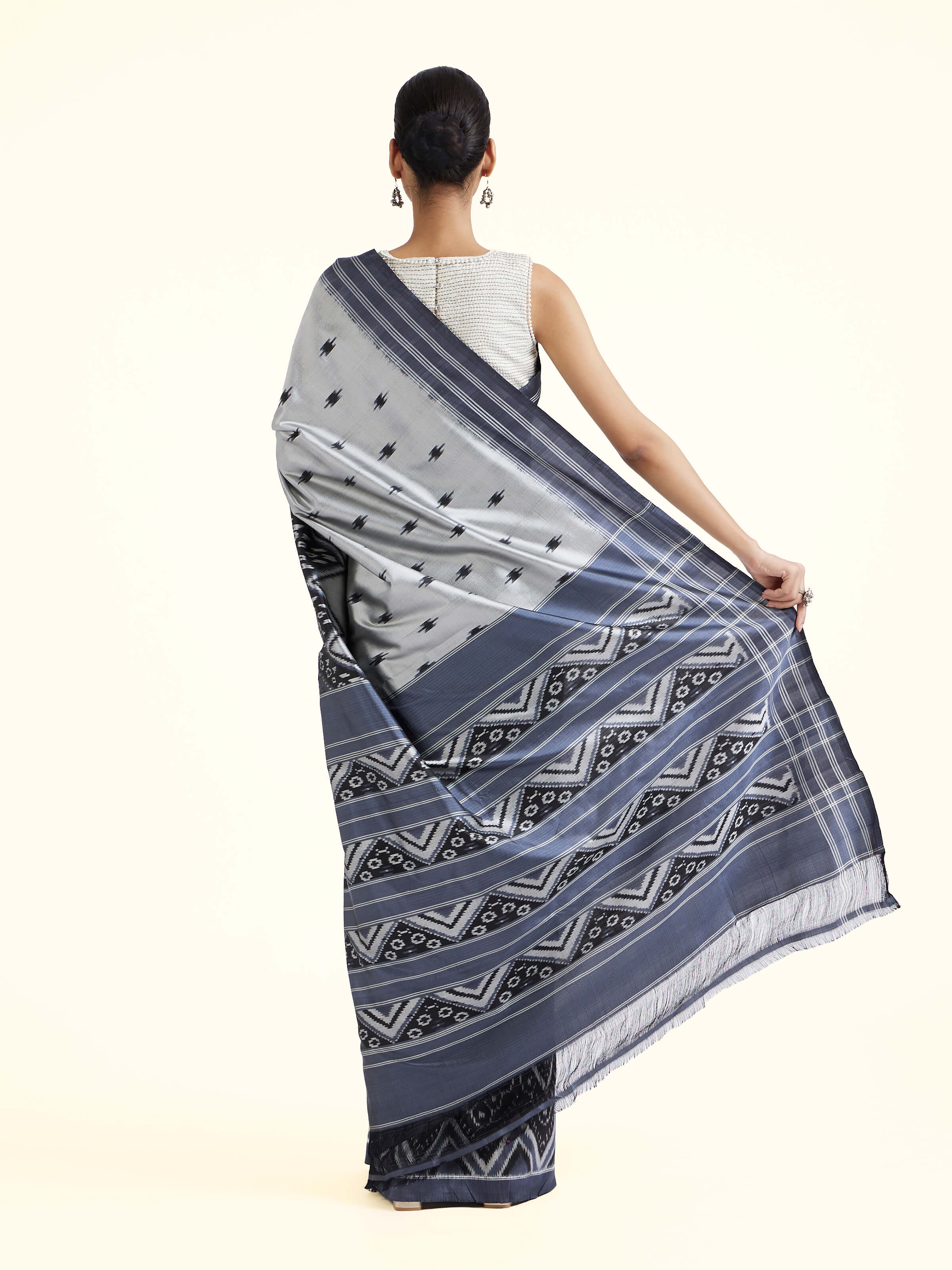 Back view of off-white mulberry silk ikat saree displaying overall design