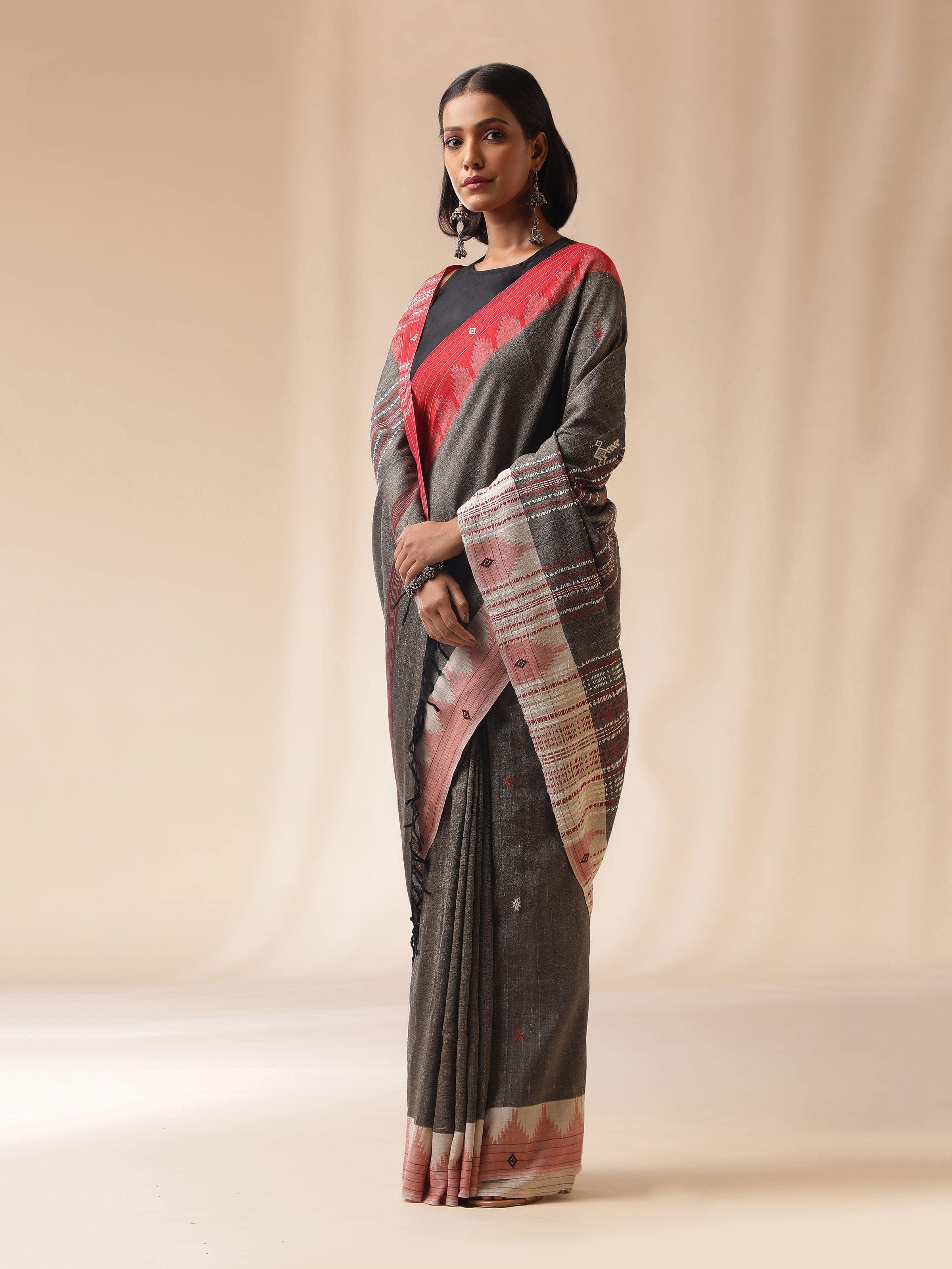 Lifestyle side view highlighting drape and woven detail of brown Kotpad saree