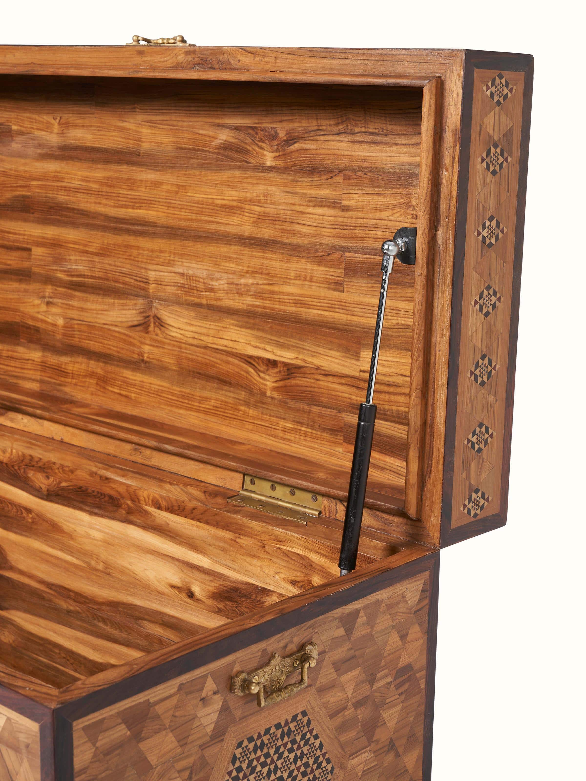 Top view of teak wood marquetry trunk with detailed inlay design, showcasing the rich textures and artistic elements.