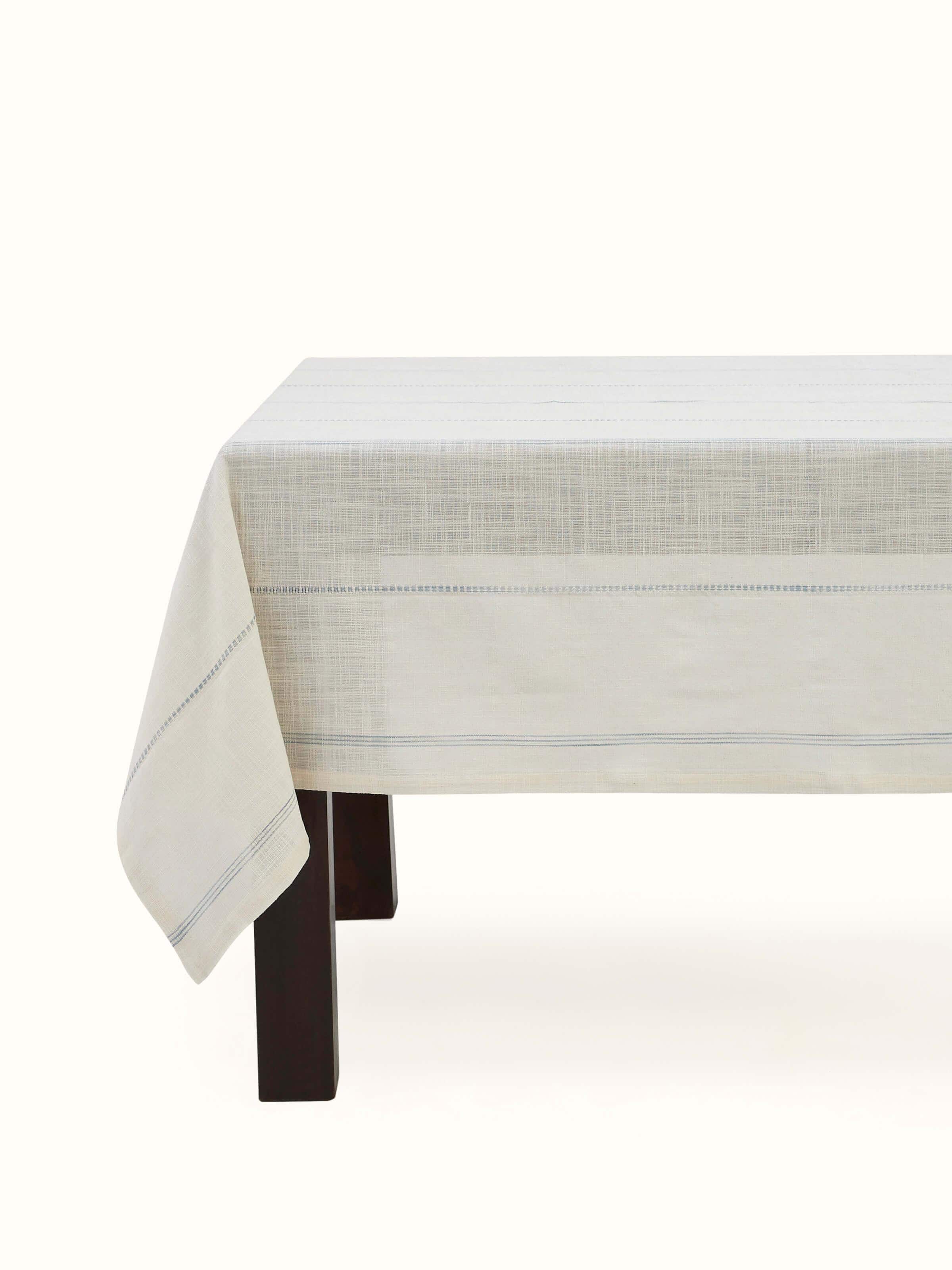Front view of Arth light blue stripe cotton handloom table cover for 4-seater table neatly spread and corner-folded.