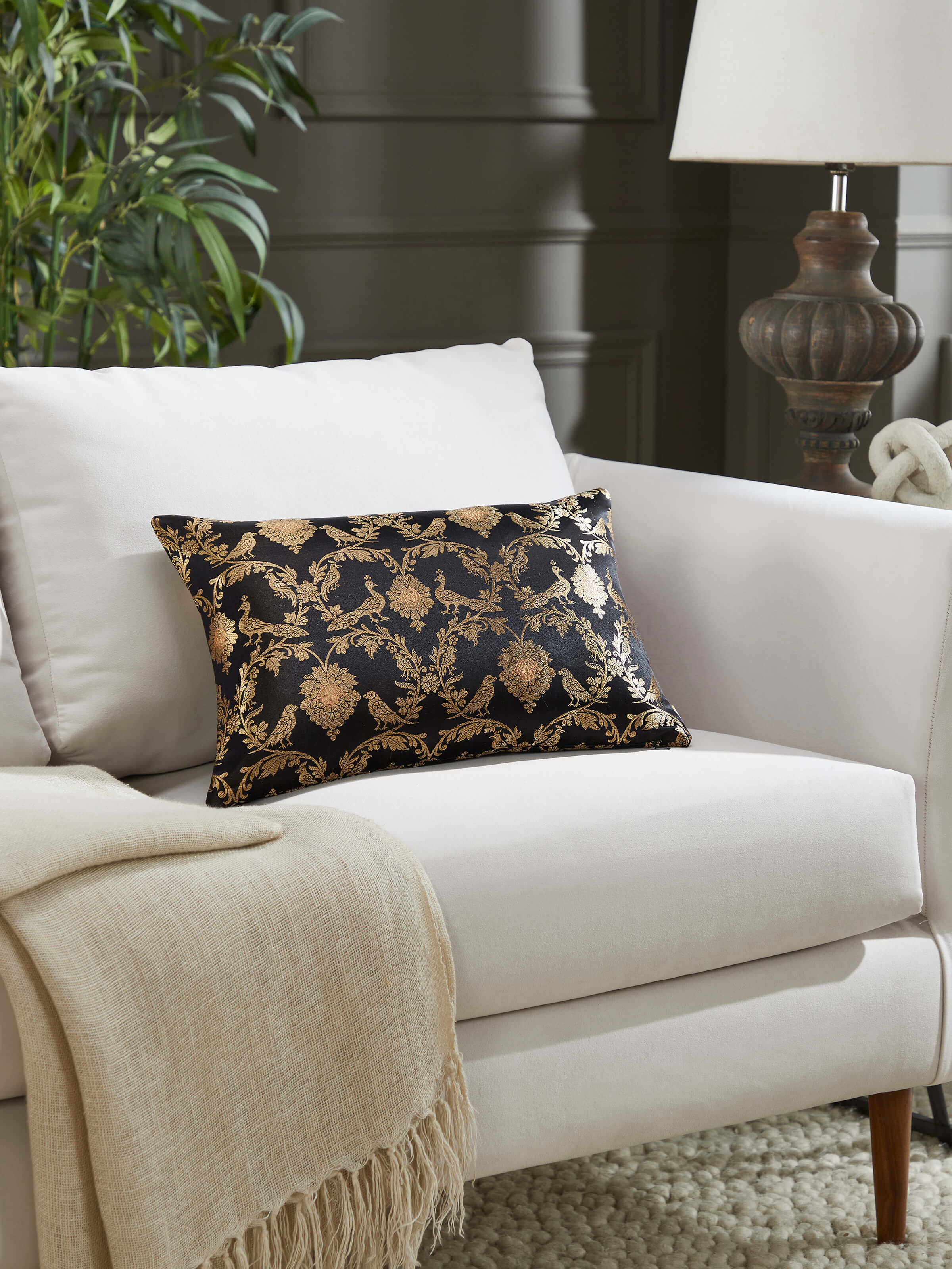Lifestyle shot of black silk cushion styled with complementing décor, offering regal elegance.