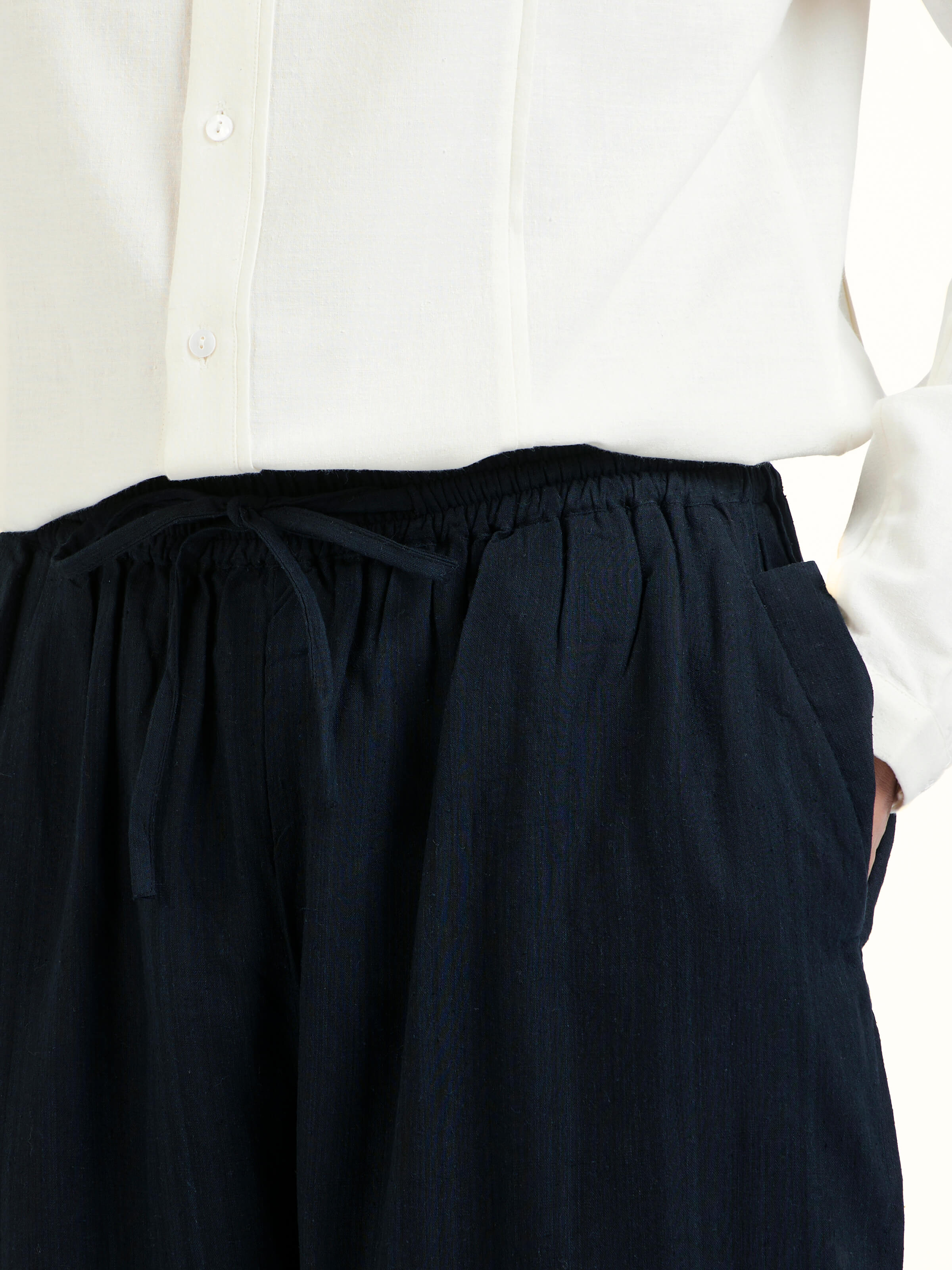 Detail view of black silk handloom straight pants showing weave texture and stitching