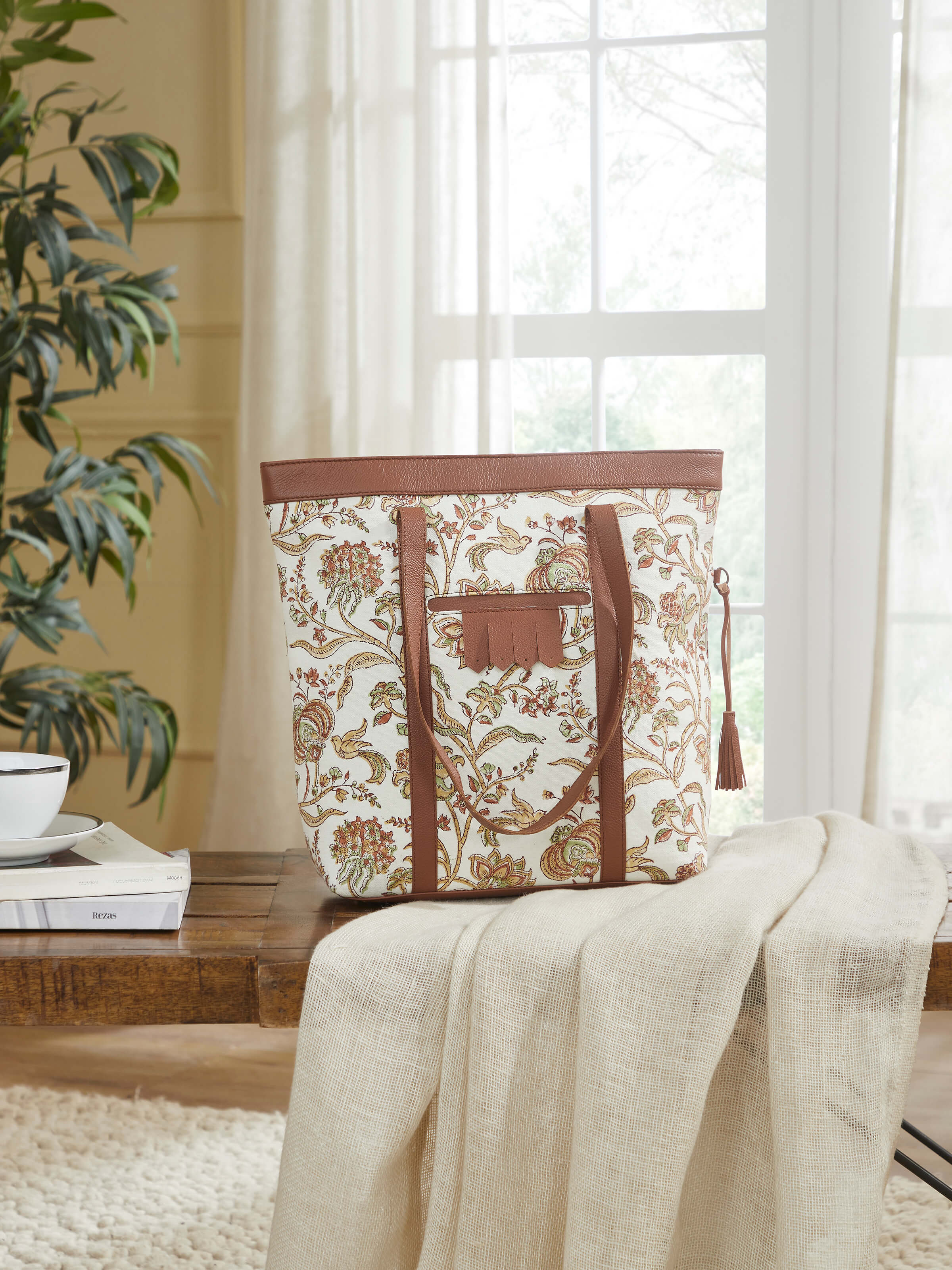 Lifestyle shot of mustard leather and textile hand block printed tote bag carried by model.