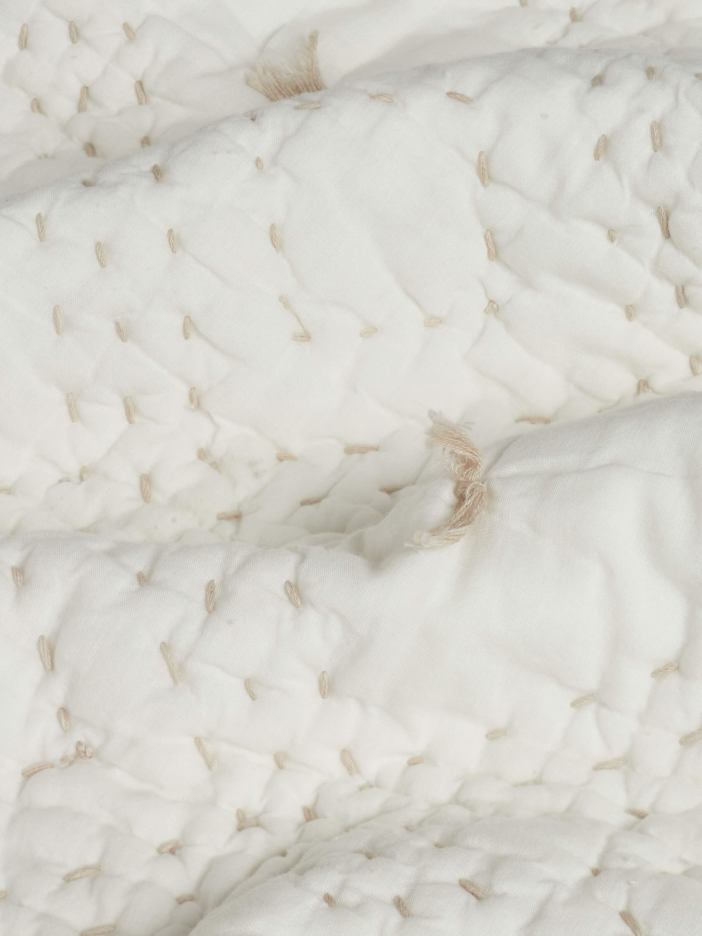 Nihar ivory diamond geo cotton razai embroidered double bedspread set (3 pcs) spread on a bed to showcase its complete look and design.