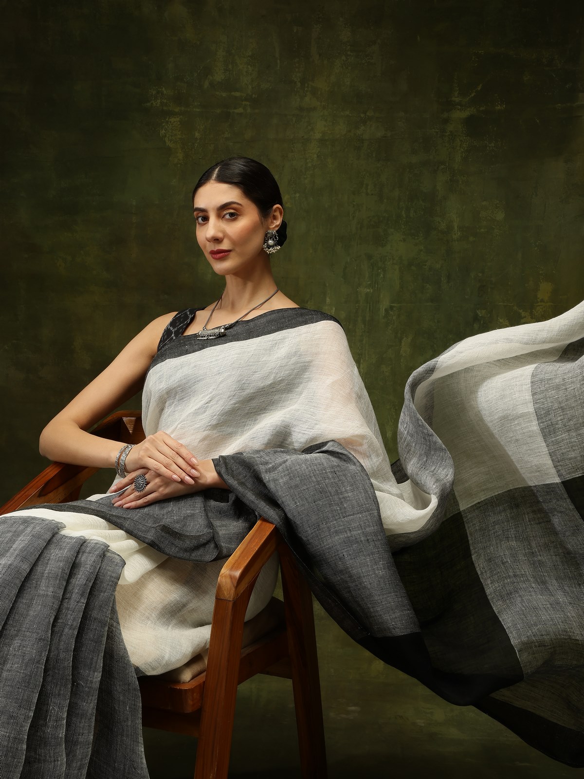 Lifestyle side view of black linen saree highlighting fluid drape and soft texture
