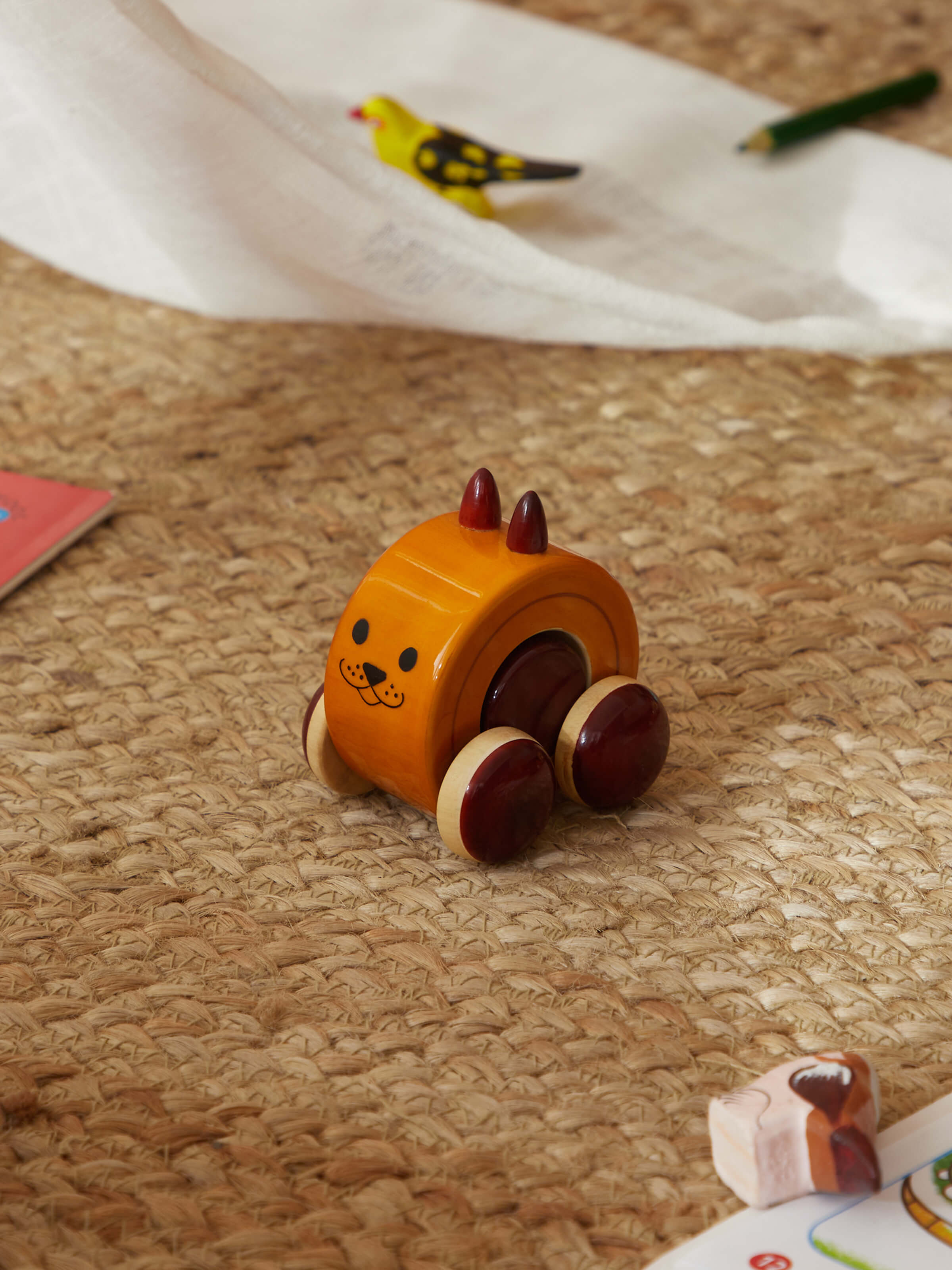 Side view of Channapatna Ivory Wood Moee Toy Yellow highlighting details