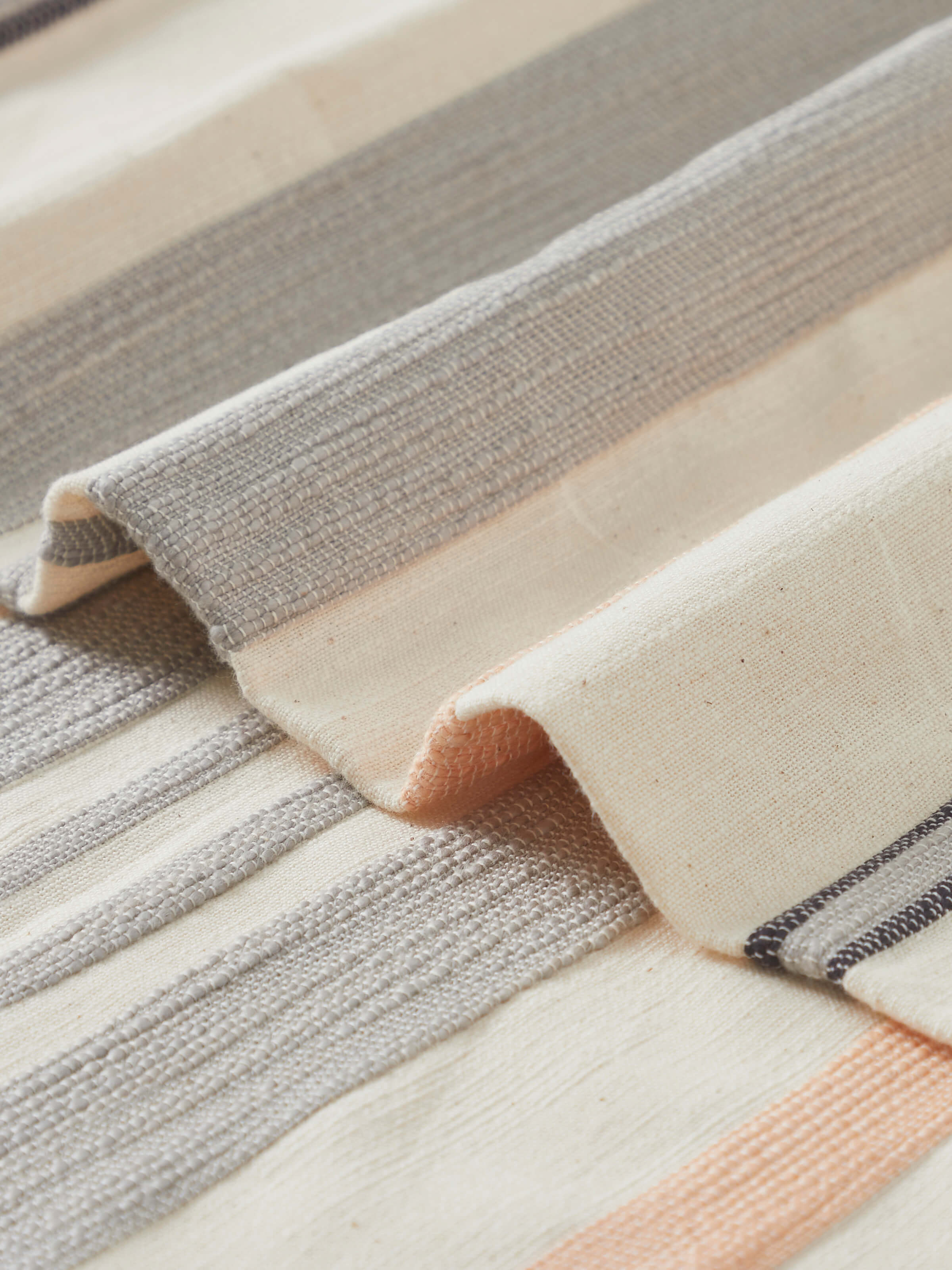 Detail view highlighting the handloom weave and subtle stripe gradation in Neerja grey cotton bedspread