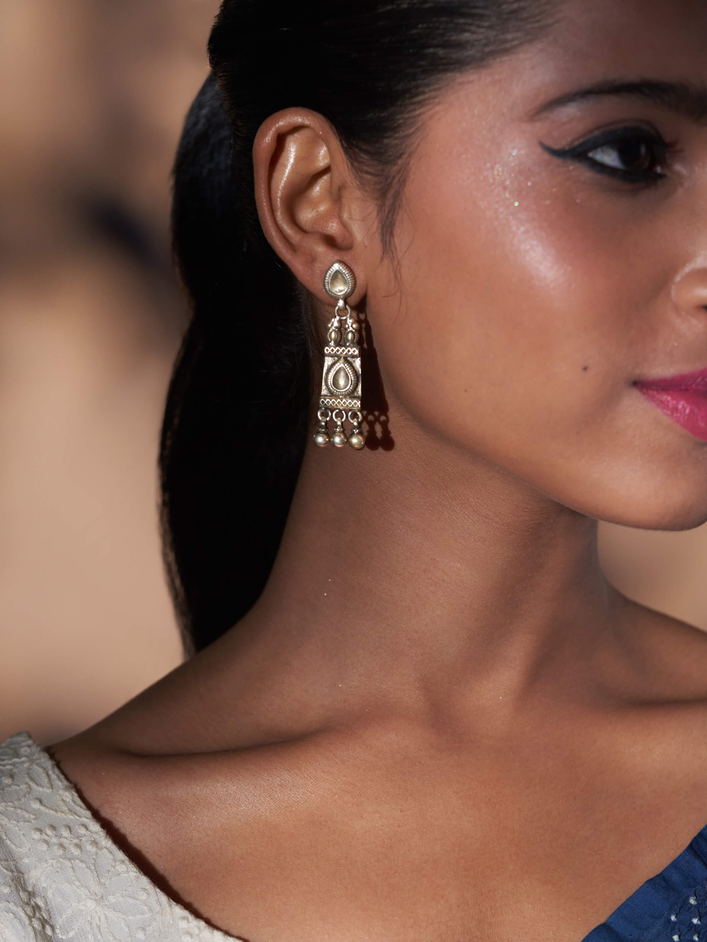 Side view of Smithing drop earrings highlighting intricate design