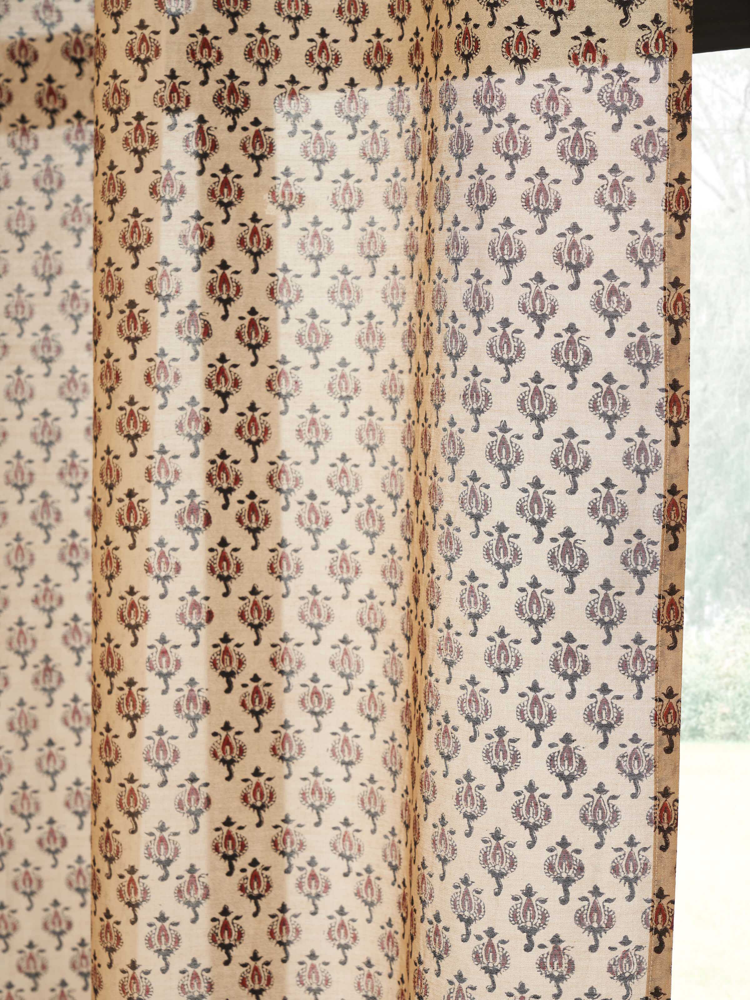 Close-up of traditional Bagru block printed buti on rust sheer curtain.