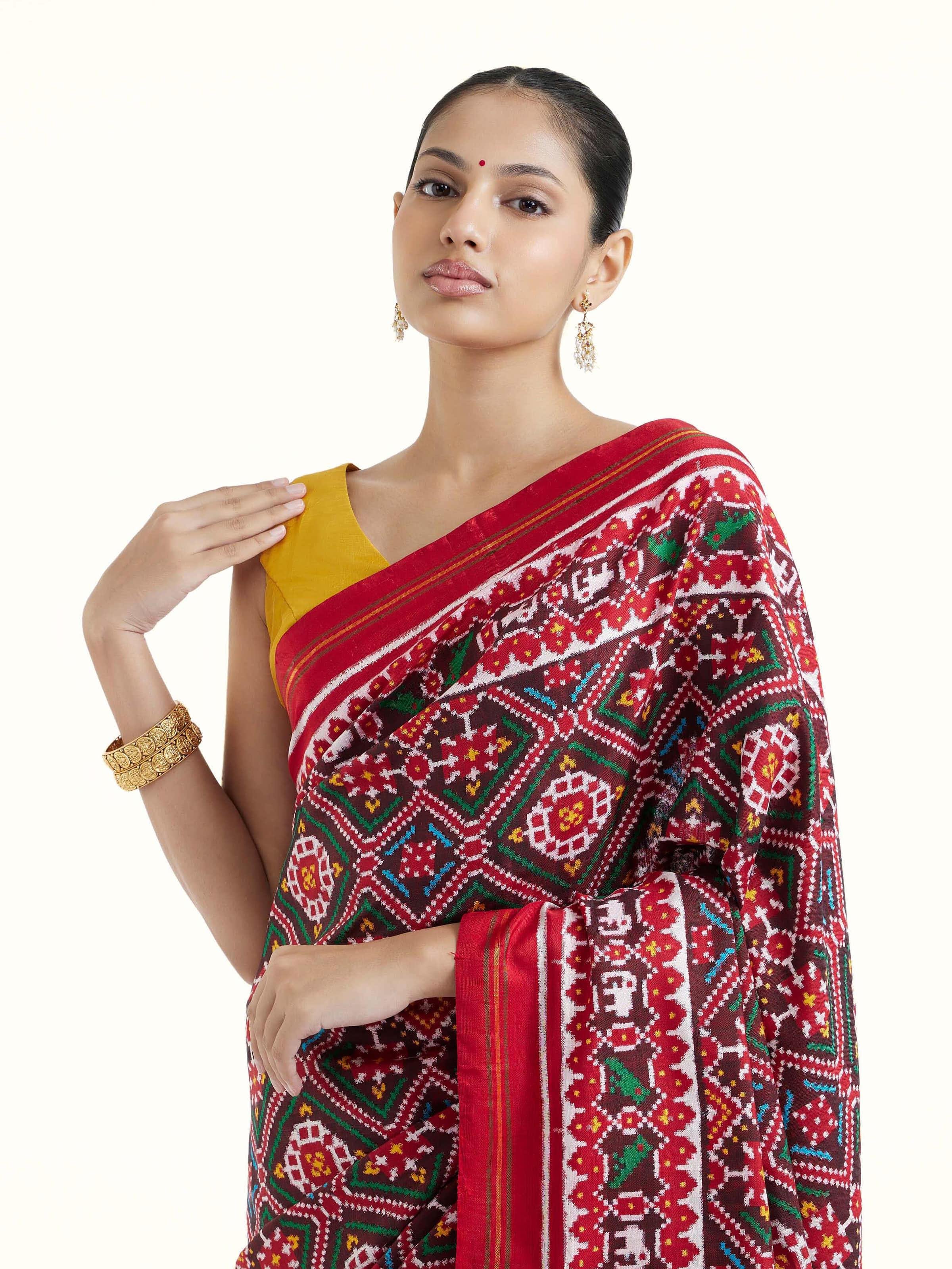 Angled view of brown silk Patola saree emphasizing geometric motifs and weave